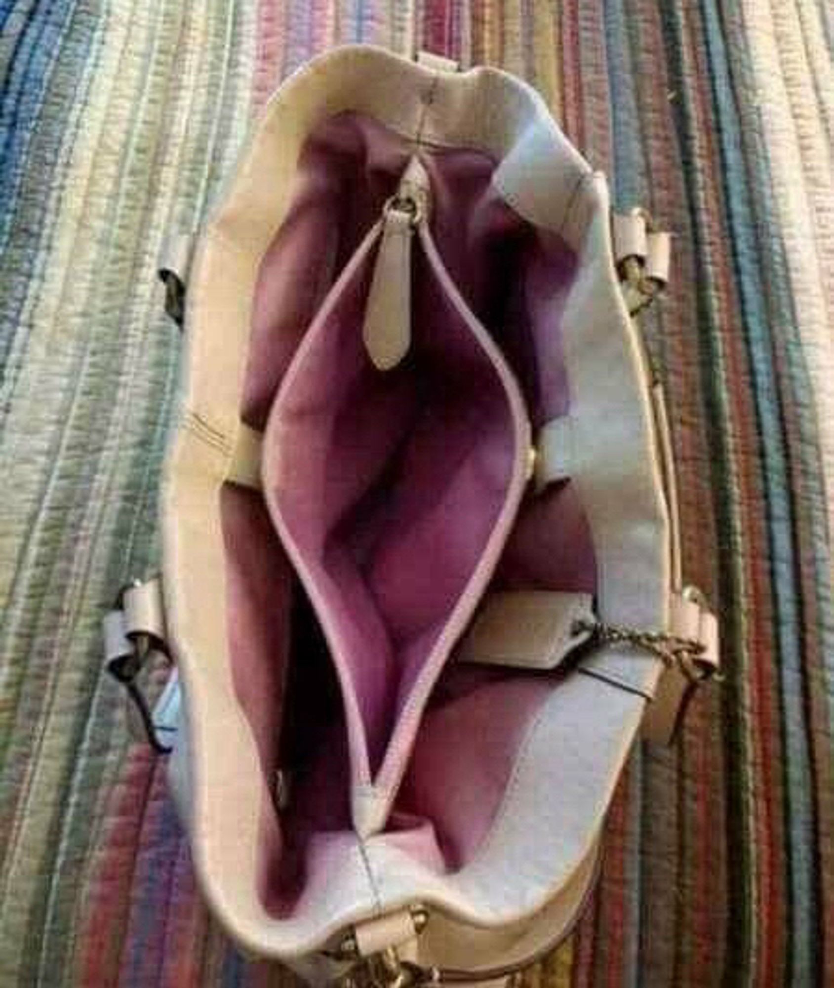 Eine Handtasche, die aussieht wie eine Vulva; der Griff vom Reißverschluss der Innentasche ist da, wo die Klitoris ist, wäre die Tasche wirklich eine Vulva.