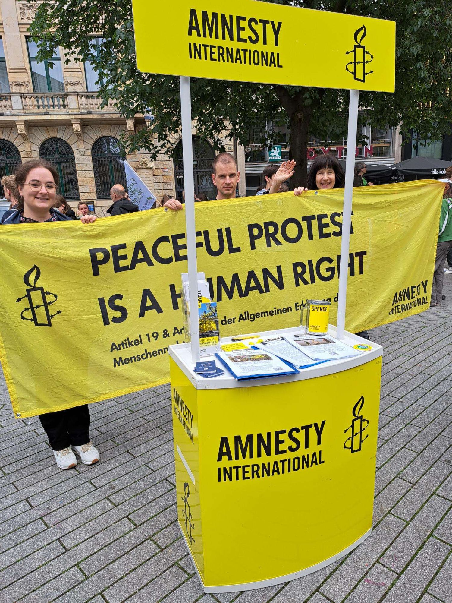 Infostand von Amnesty International mit Banner "Peaceful Protest is a human right"