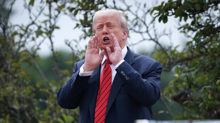 Donald Trump cupping his hands as if to make his voice louder. What a jerk. 