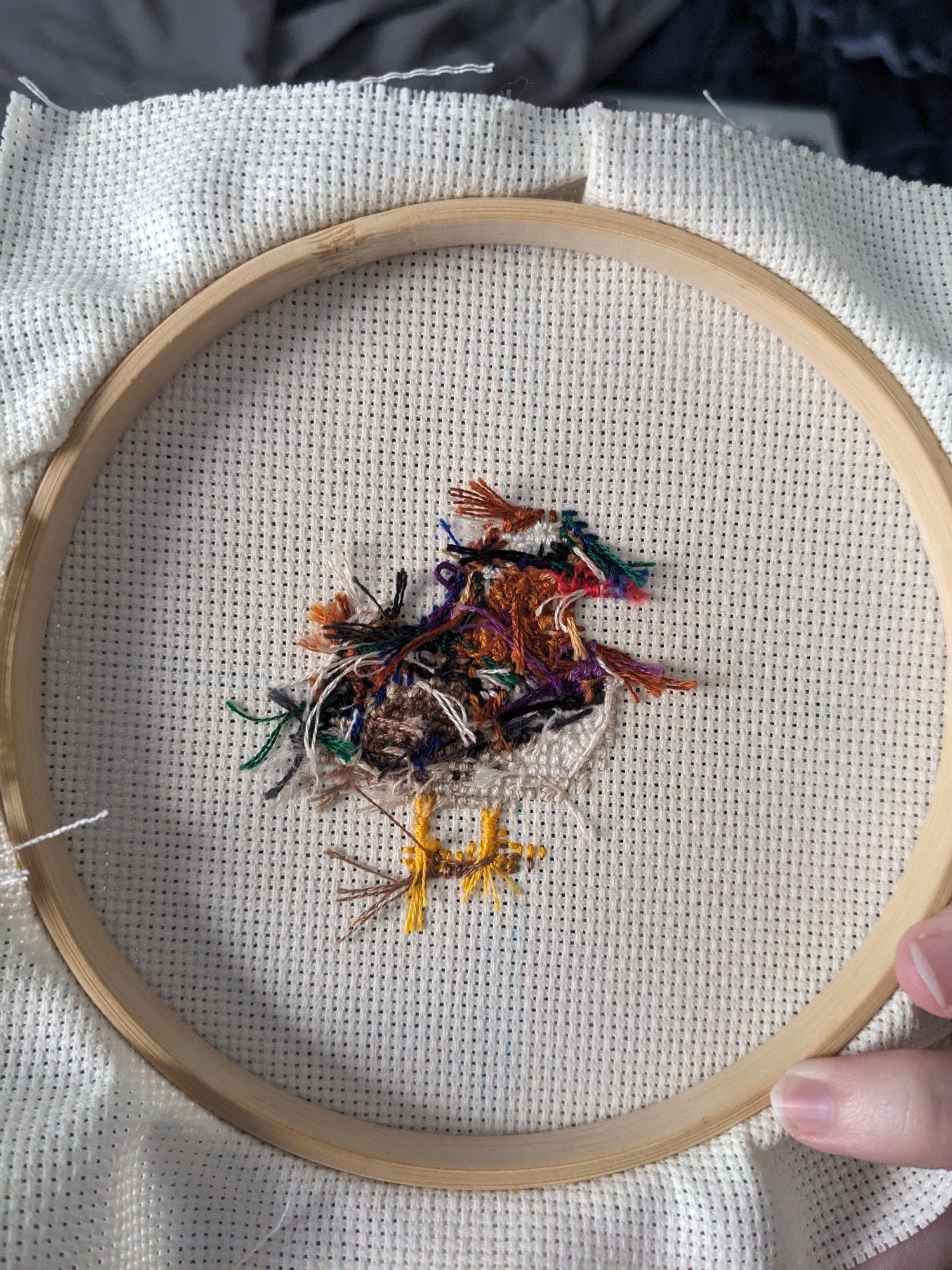 Cross stitched side of the duck, back side of the work, messy with string