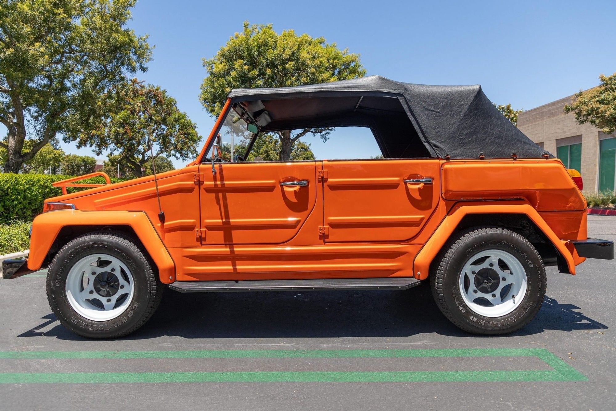 Picture of the side of an orange with black top convertible Volkswagen Model 181, colloquially known as the "Thing"