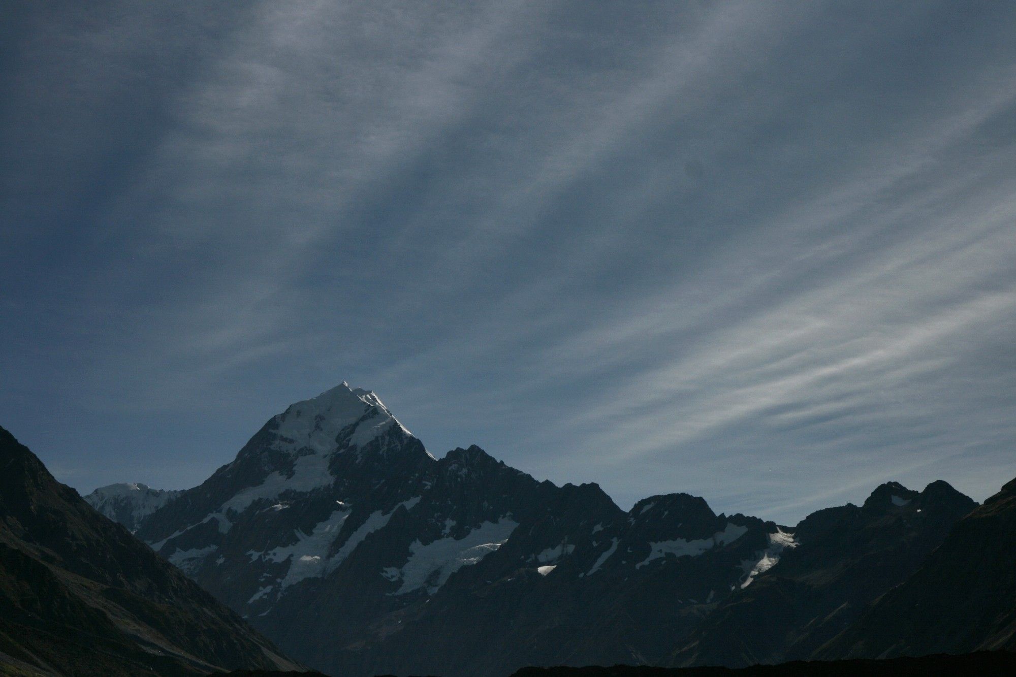 A foto of a mountain against a striated sky