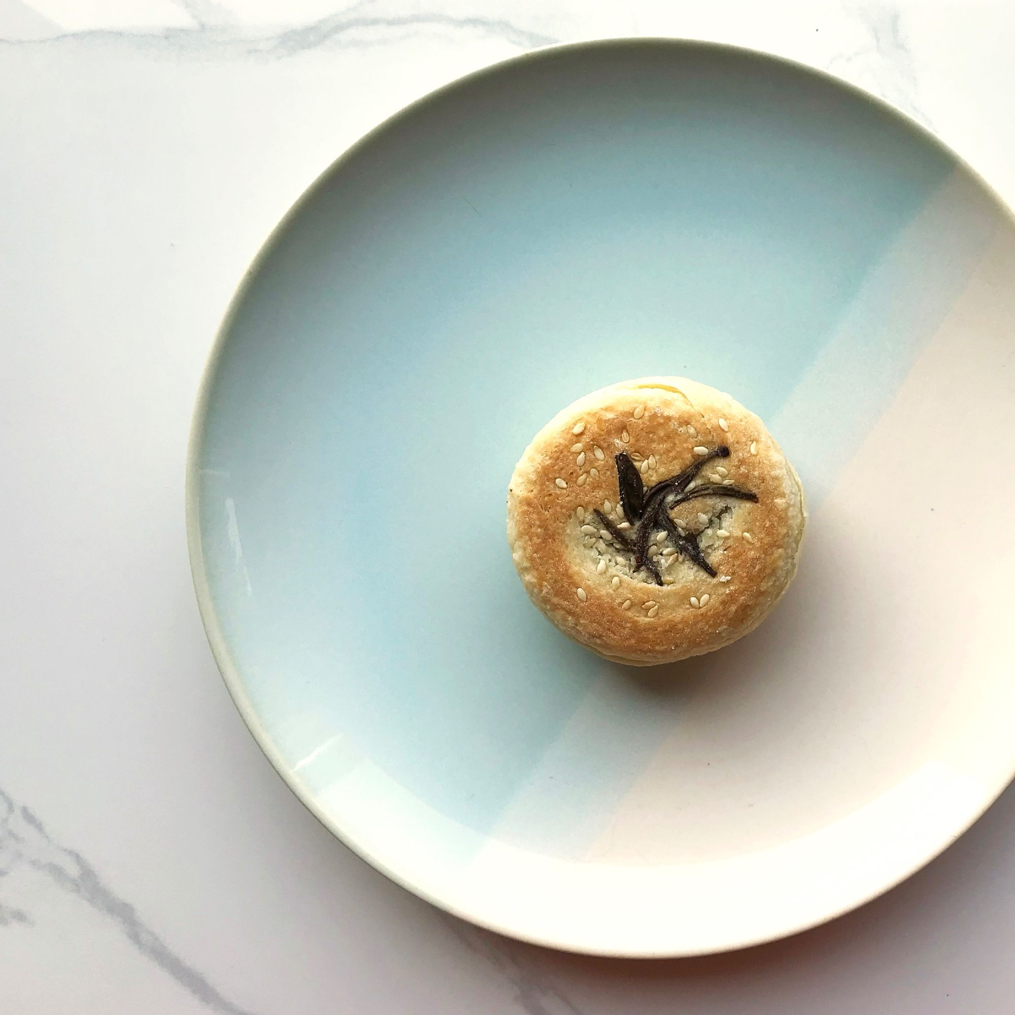 A Yunnan-style ham mooncake, topped with sesame seeds and tea leaves.