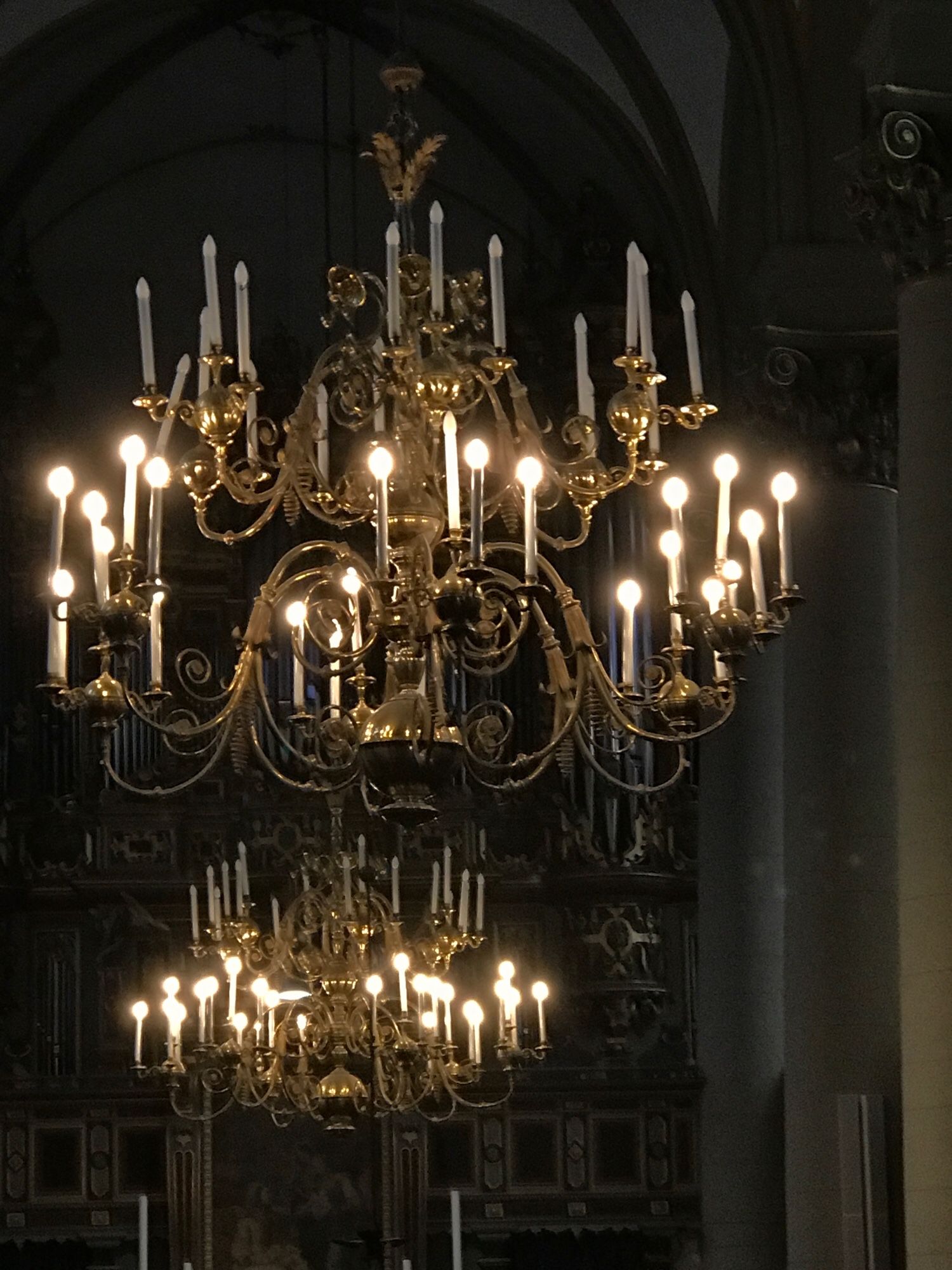 Two large brass chandeliers in a dark room. The candles of each lower part are alighted
Location: the town church of Bückeburg/ Lower Saxony