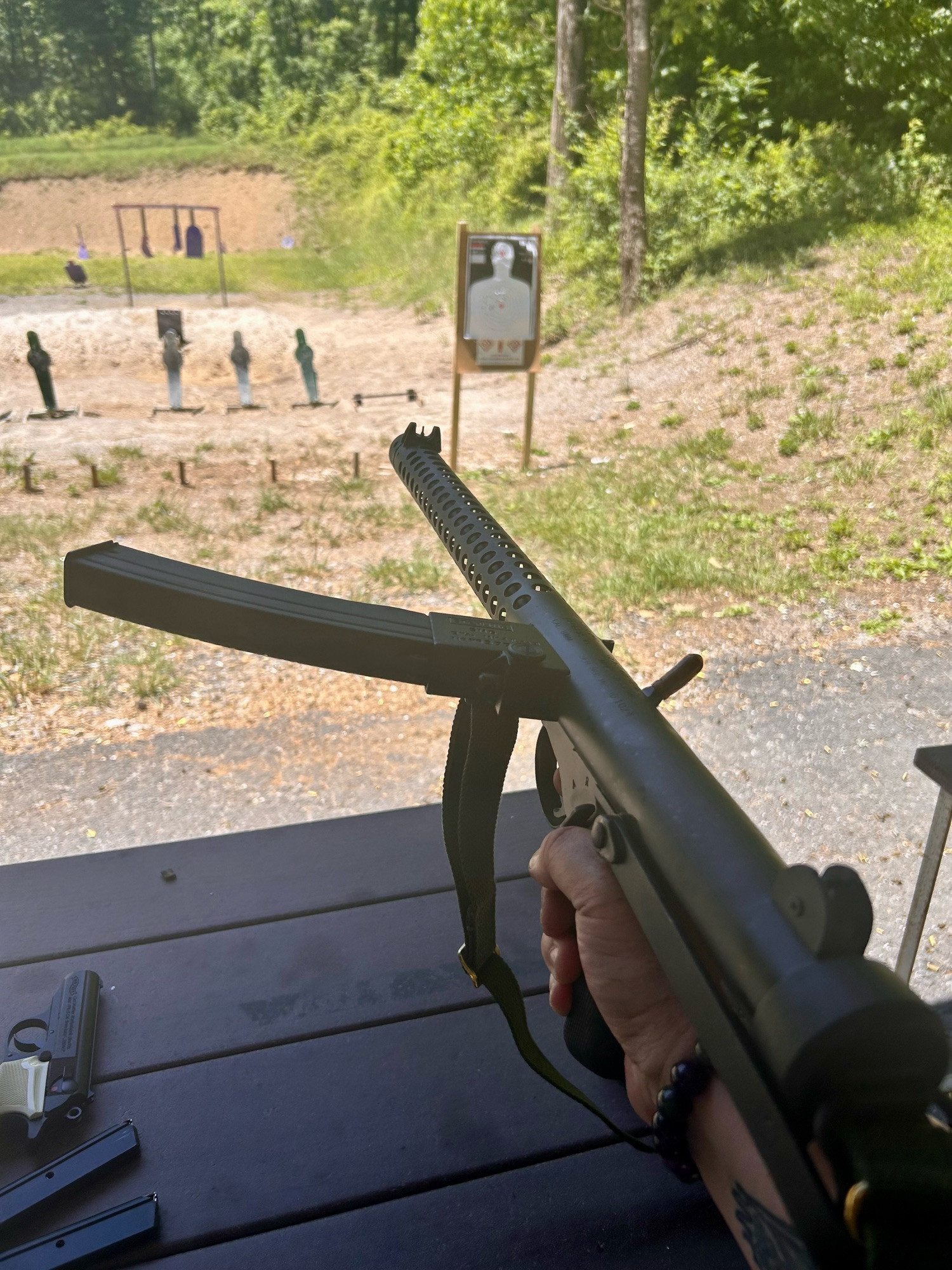 Me holding The GothGun at my range earlier today. It is a hideous, angular piece of death plumbing designed to throw 9mm projectiles at things. It is completely ridiculous that a civilian can own this but I refuse to let the Nazis/Fash/Magats have all the guns. There is also a Walther PPK on the table. It is almost quaint compared to the GothGun. An elegant weapon for a more civilized age.