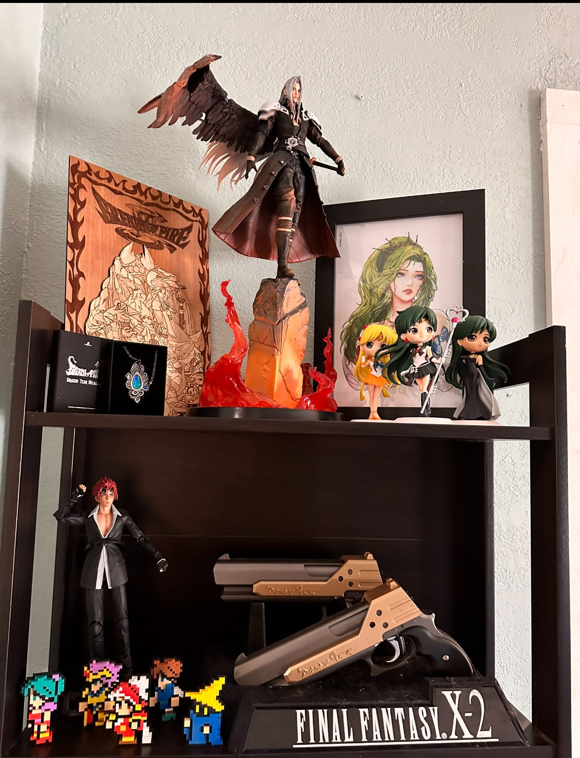 Several items of gaming memorabilia such as a hot bitch Reno statue, 19 inches of Sephiroth, and Final Fantasy X-2 gun controllers.