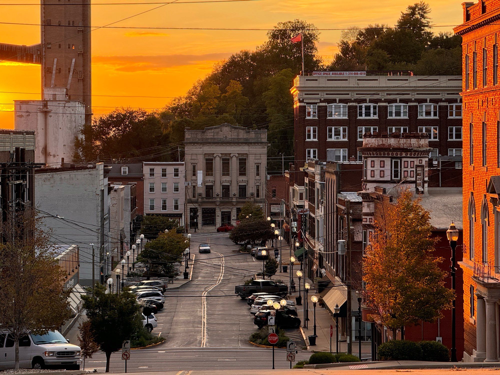 a gorgeous photo looking westward down historic Third Street in Alton, Illinois. the street is super wide; the sidewalks are also super wide. you could fit three townhouses side by side in its gap and it wouldn't even be snug.