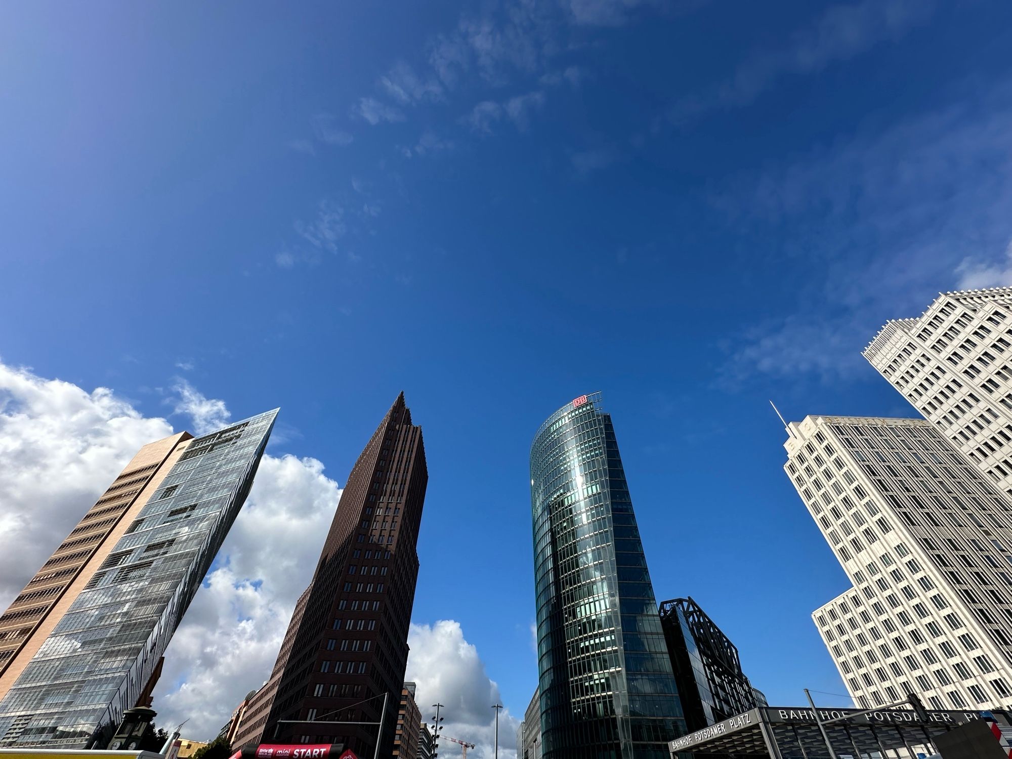 Hochhäuser am Potsdamer Platz vor blauen Himmel, unten der schwarz-rote Startbogen.