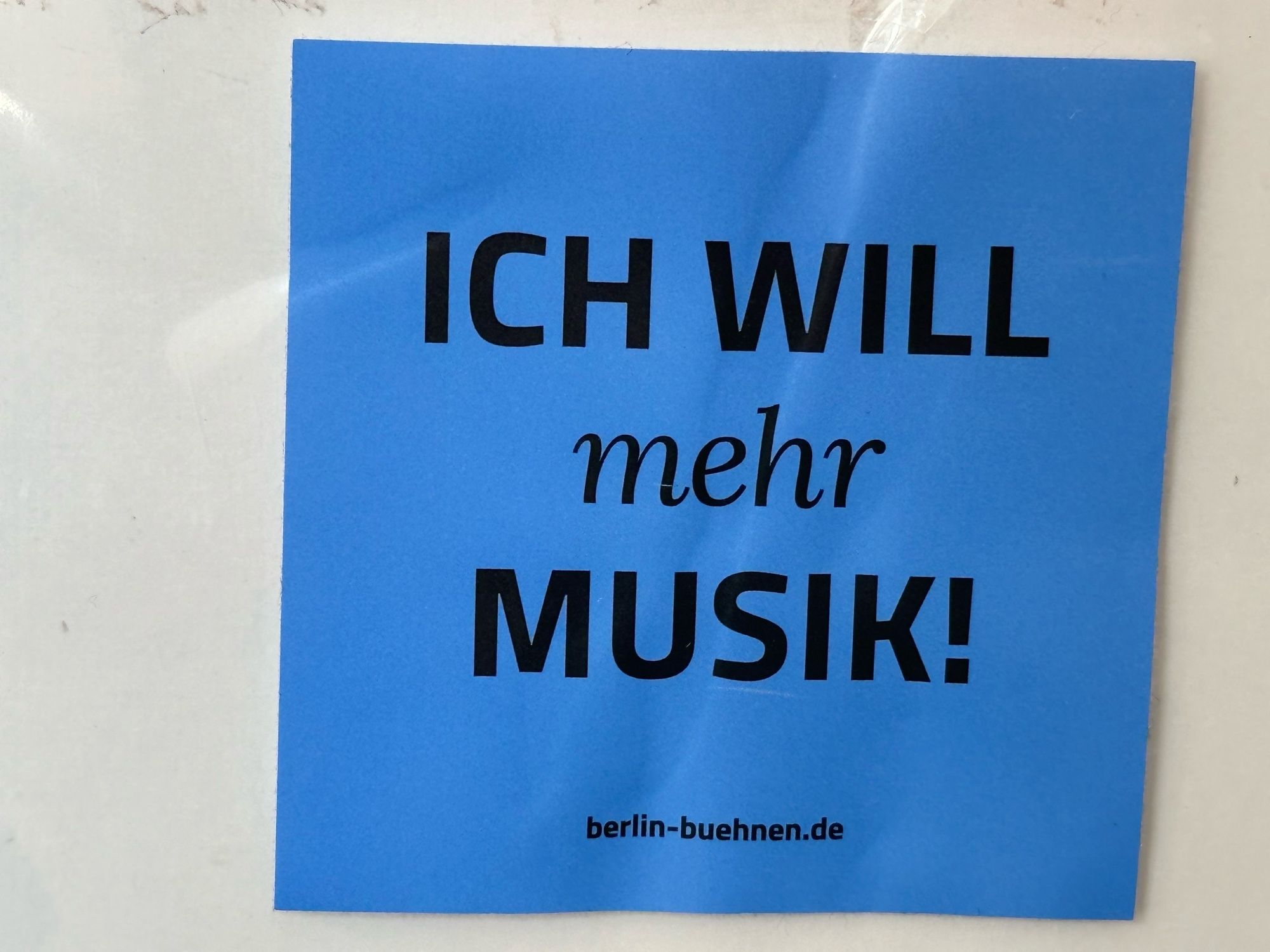 Blauer Aufkleber mit dem Text 
ICH WILL
mehr
MUSIK!