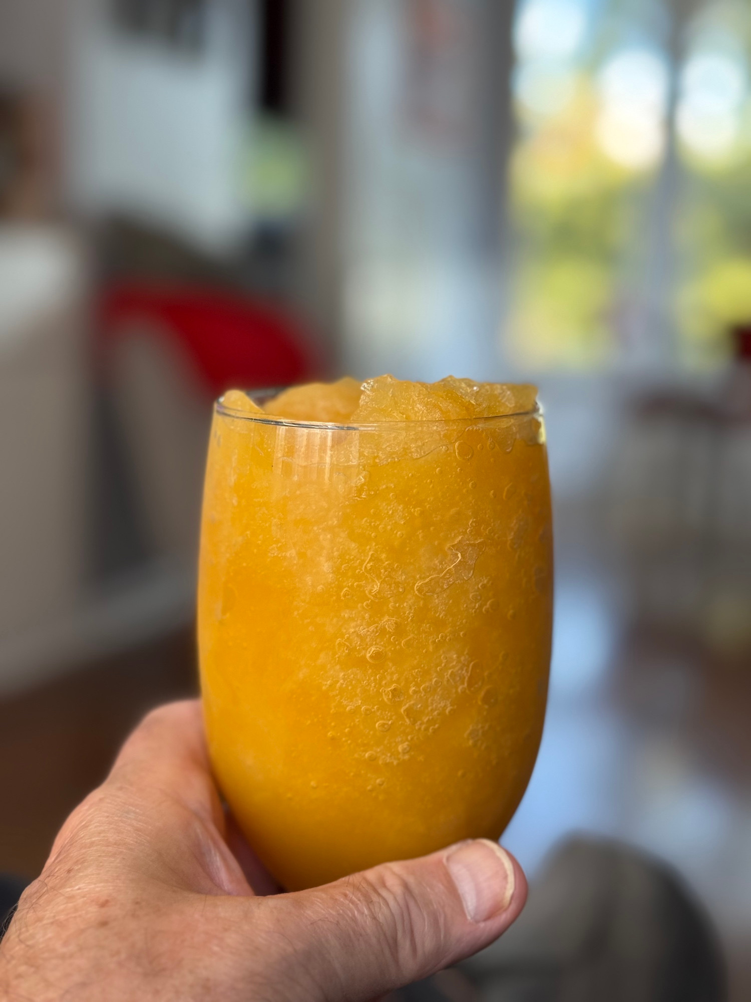 A frozen bourbon slush in a clear goblet.