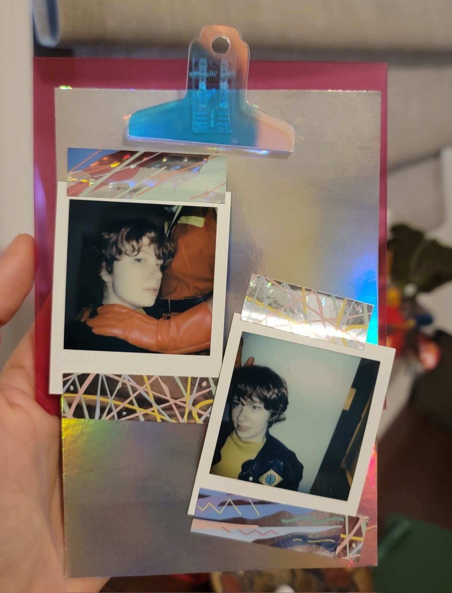 Two Polaroids of my charmuro cosplay washi taped onto a recycled piece of iridescent cardboard and clipped onto a clipboard