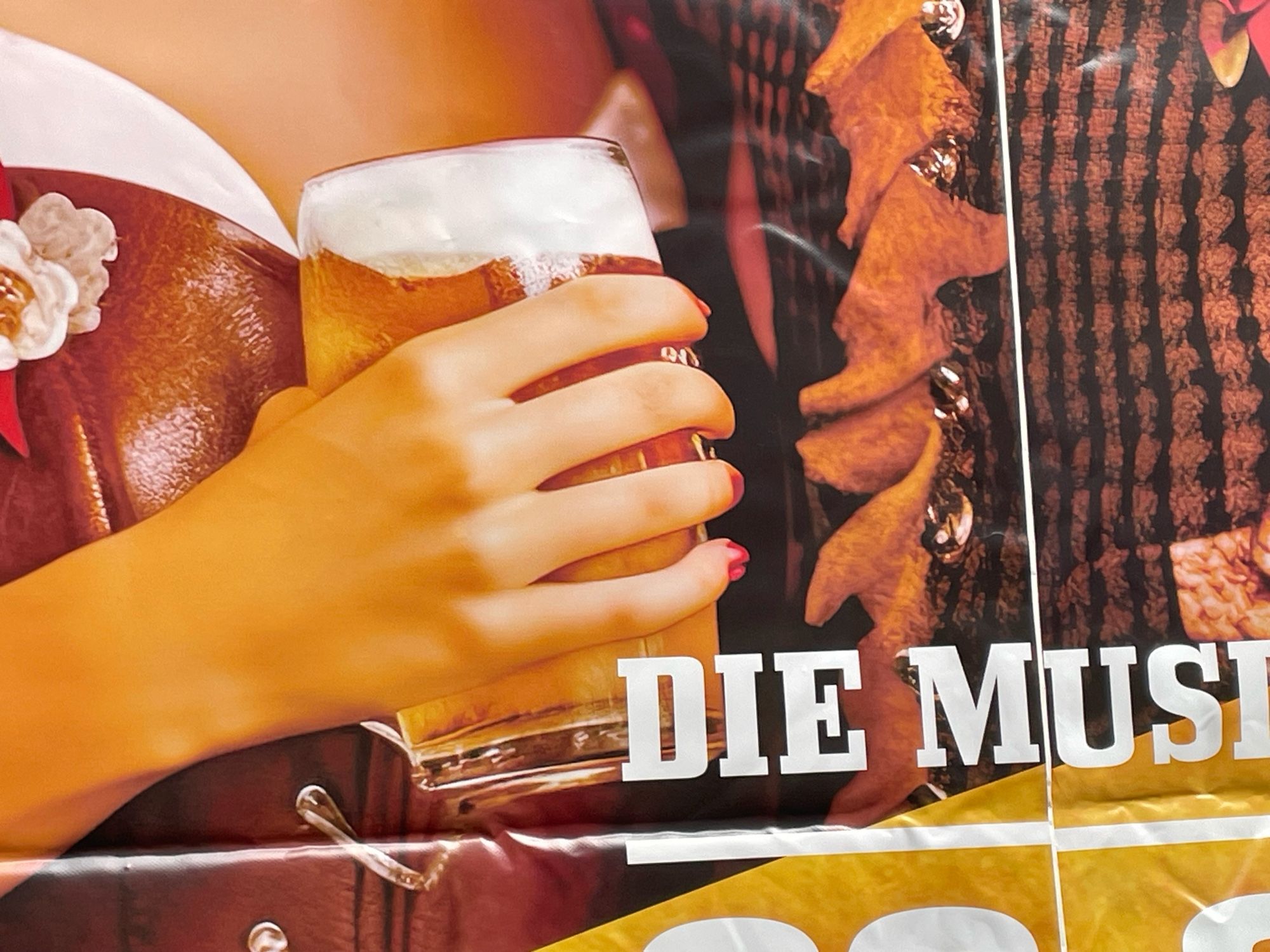 Detail aus einem Plakat, eine Hand umgreift ein Bierglas