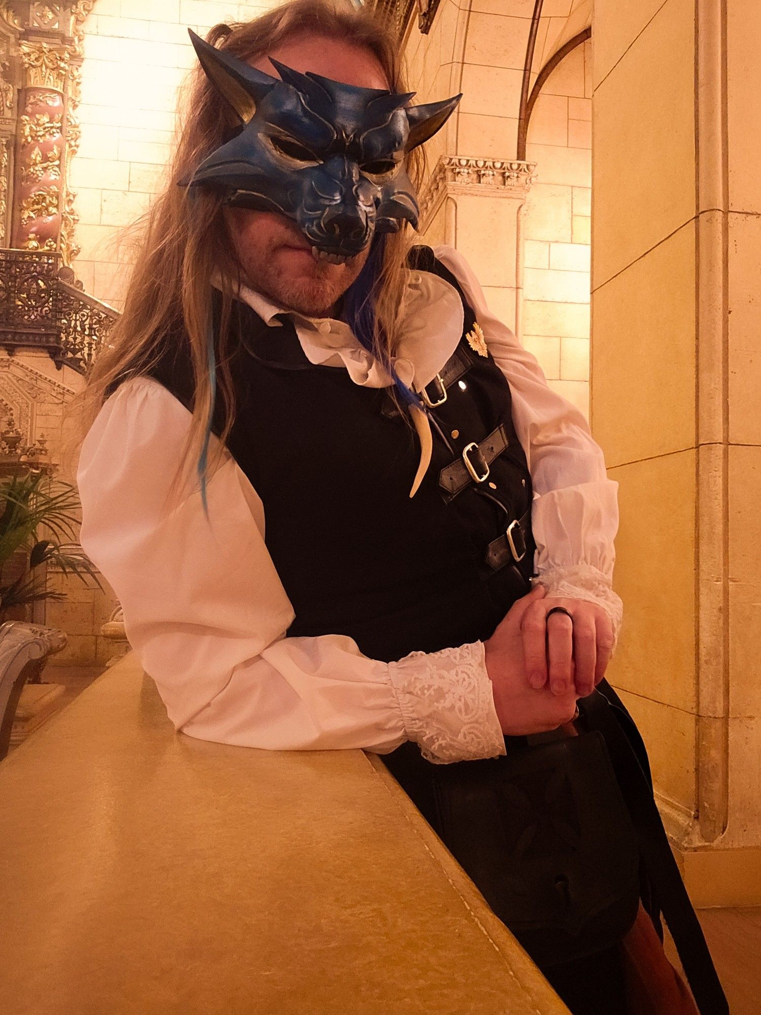 Chris in Masquerade attire, with a blue and gold wolf themed mask