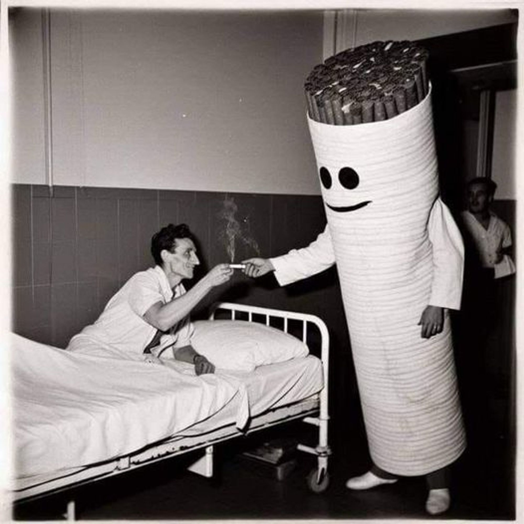 Guy in a hospital bed being handed a lit cigarette.