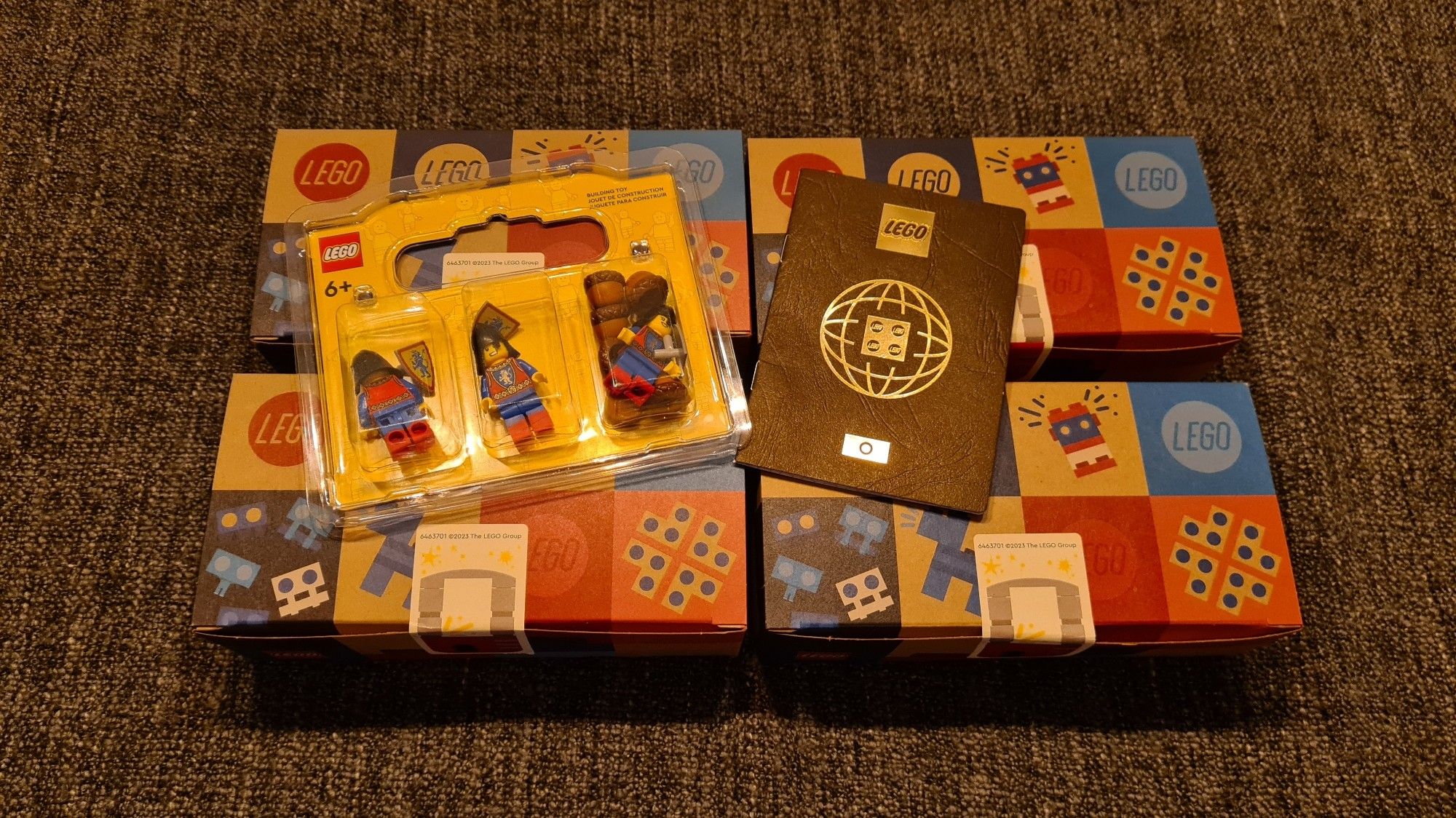 4 dozen met LEGO steentjes uit de LEGO Pick A Brick wall. Met daarop liggende een LEGO paspoort en een paar ridder minifigures.