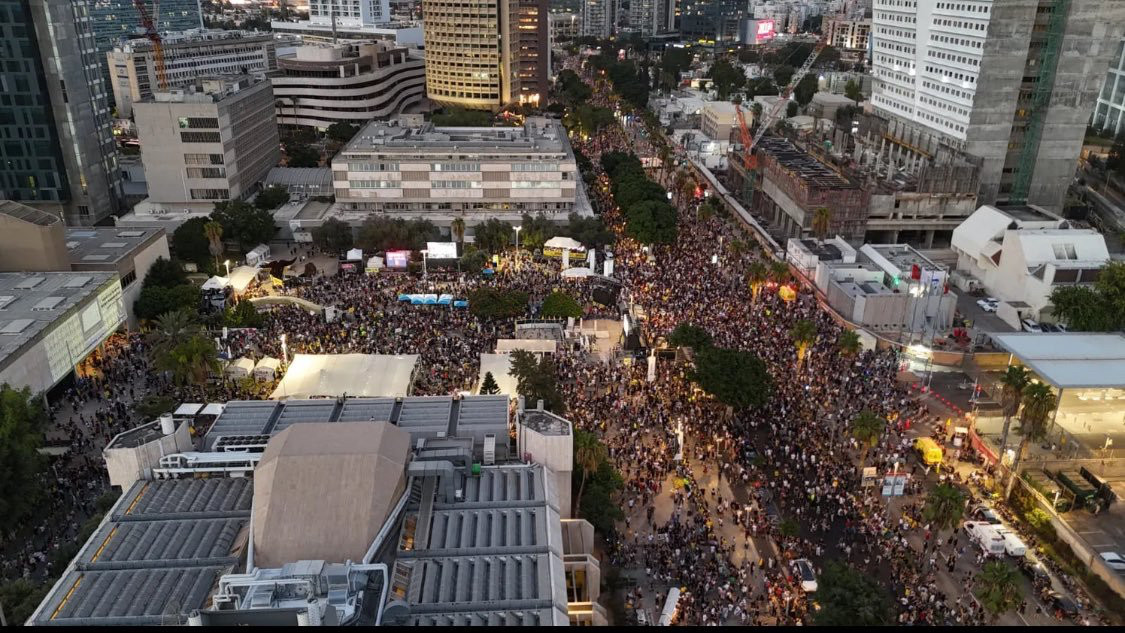 Crowds throng along a street. Do not as yet have a picture credit 