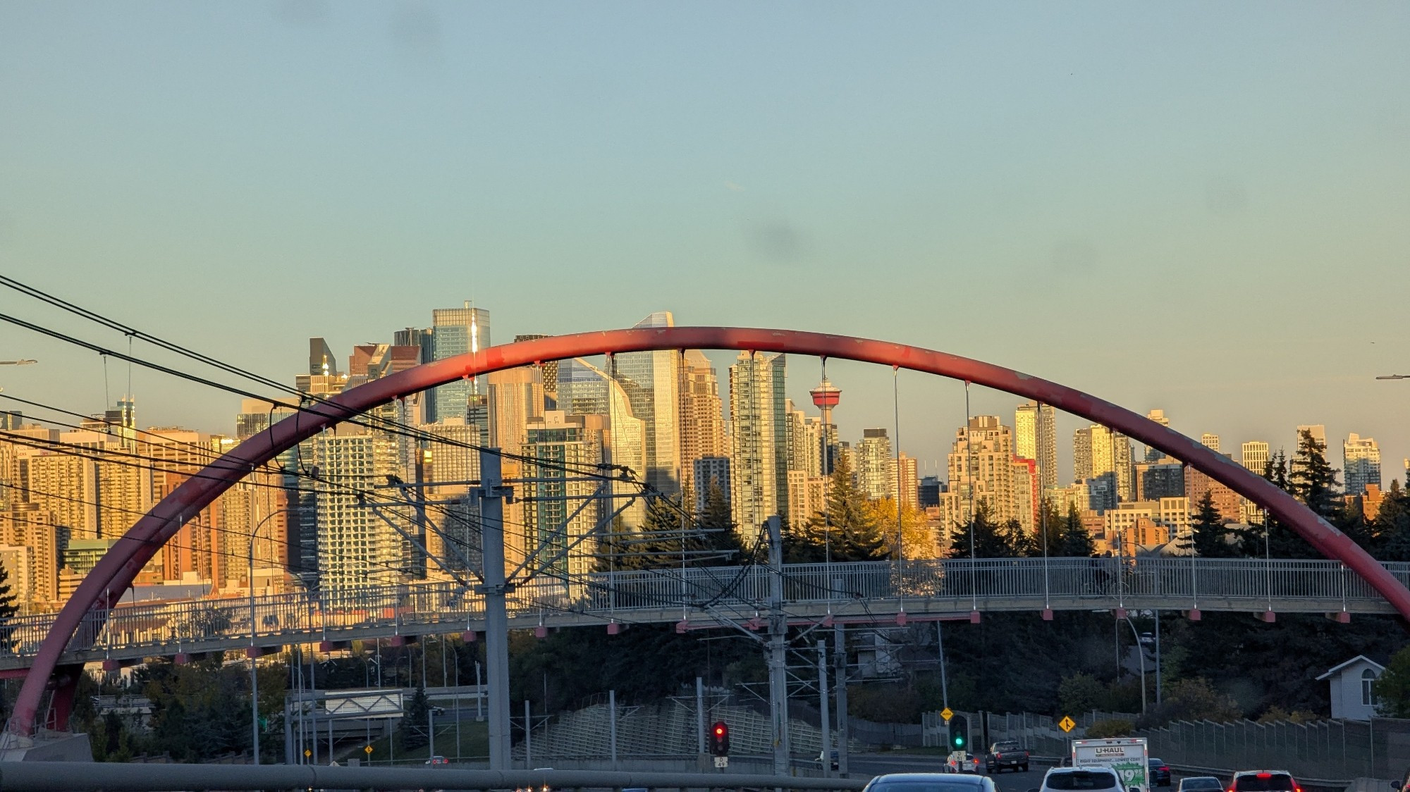 View of the Calgary skyline from the west just before sunset, with a bridge in the foreground.