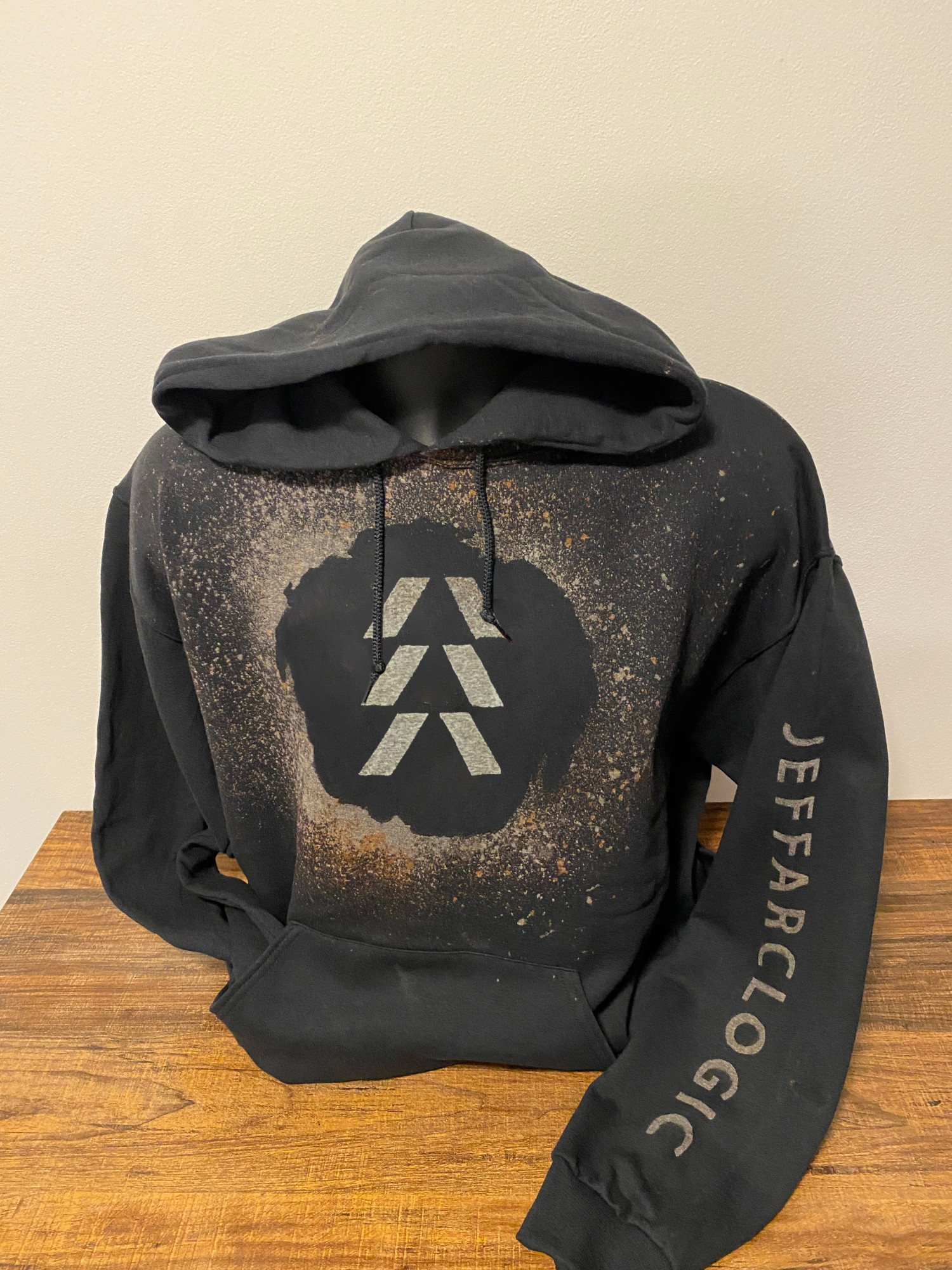 A black hoodie with a Destiny Hunter logo created out of bleach. A gamertag has been bleached down one of the arms.