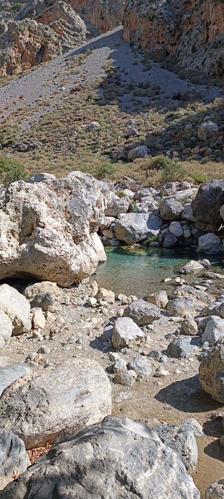 Very rocky terrain with a glimpse of turquoise water