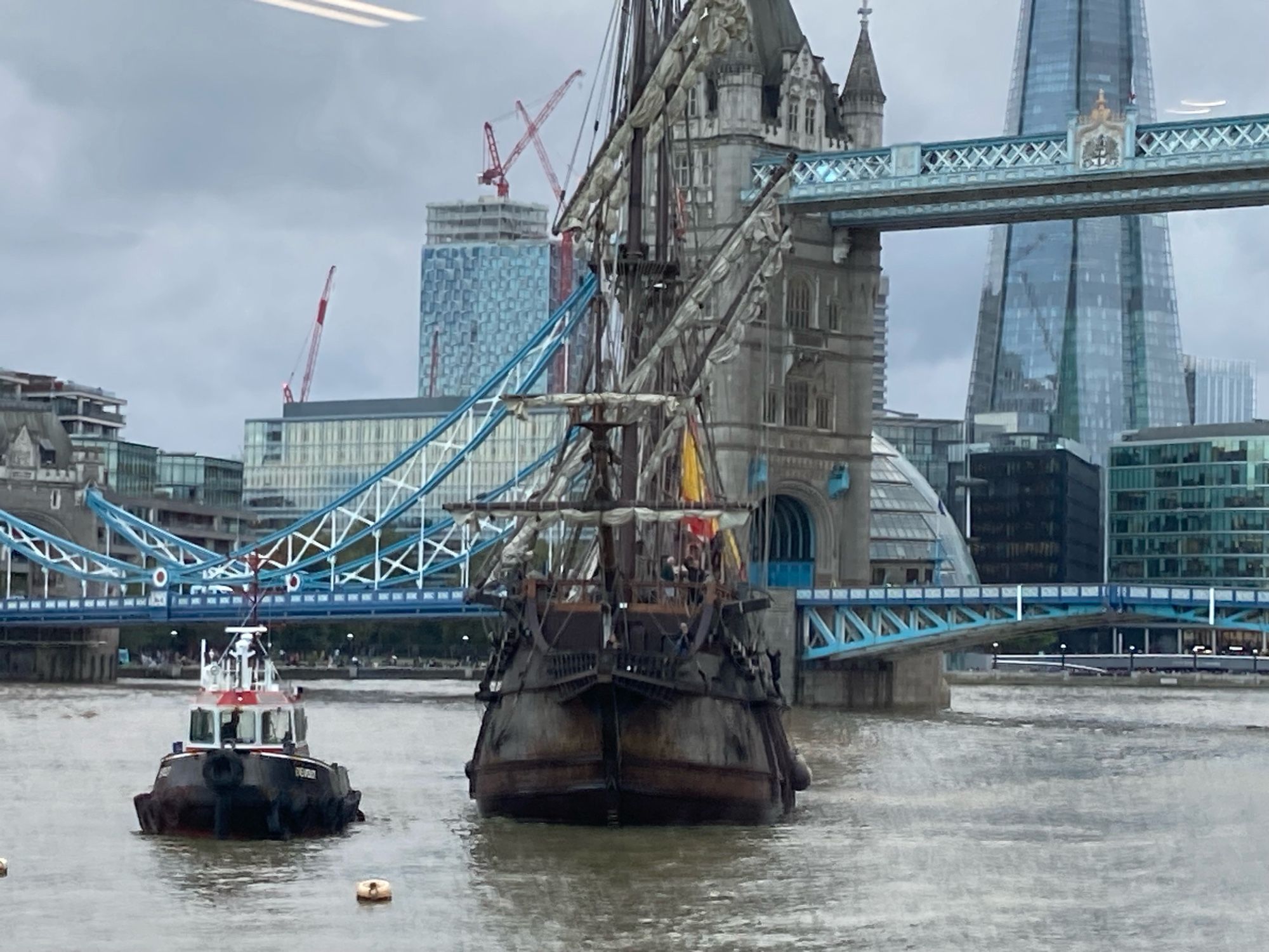 Photo of the Spanish flagged Galeon Andalucia being pulled by tug boat up the Thames in front of Tower Bridge and The Shard.