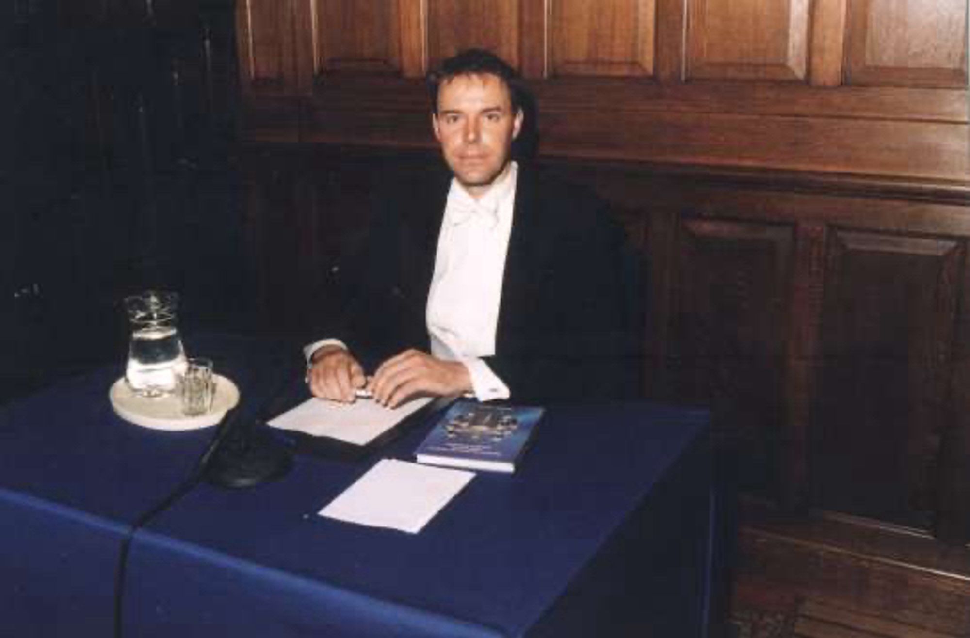 PhD defense in Groningen. Me sitting behind a table with my PhD thesis, water, and paper and pen