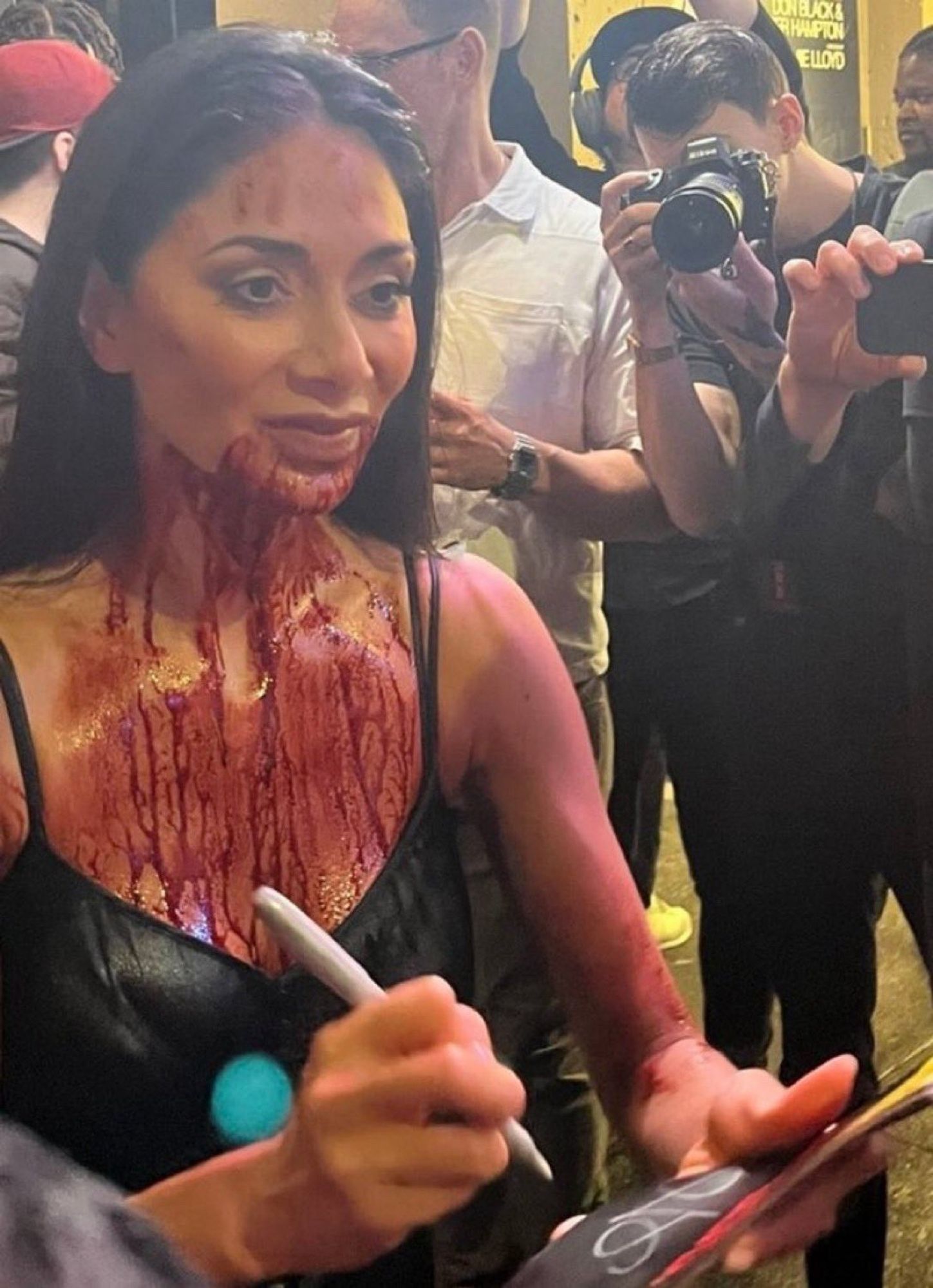 Nicole Scherzinger signing autographs after a performance of Sunset Blvd covered in fake blood from the neck down.