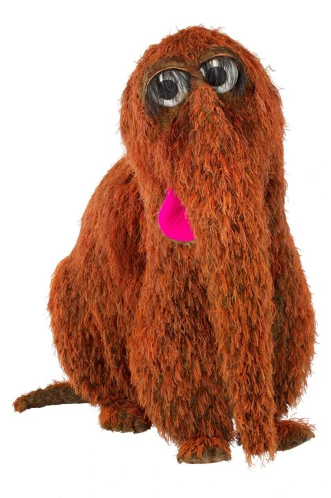 ID: Snuffleupagus Muppet, a large Muppet with brown fur, a pink tongue, and large trunk and tail sits on hindlegs.