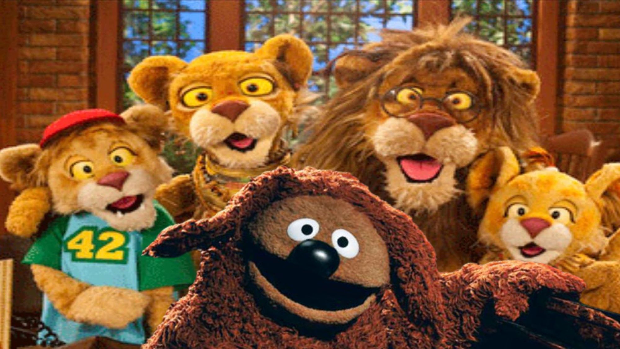 ID: a family of four Muppet Lions stand together with Rowlf in the front by a piano.