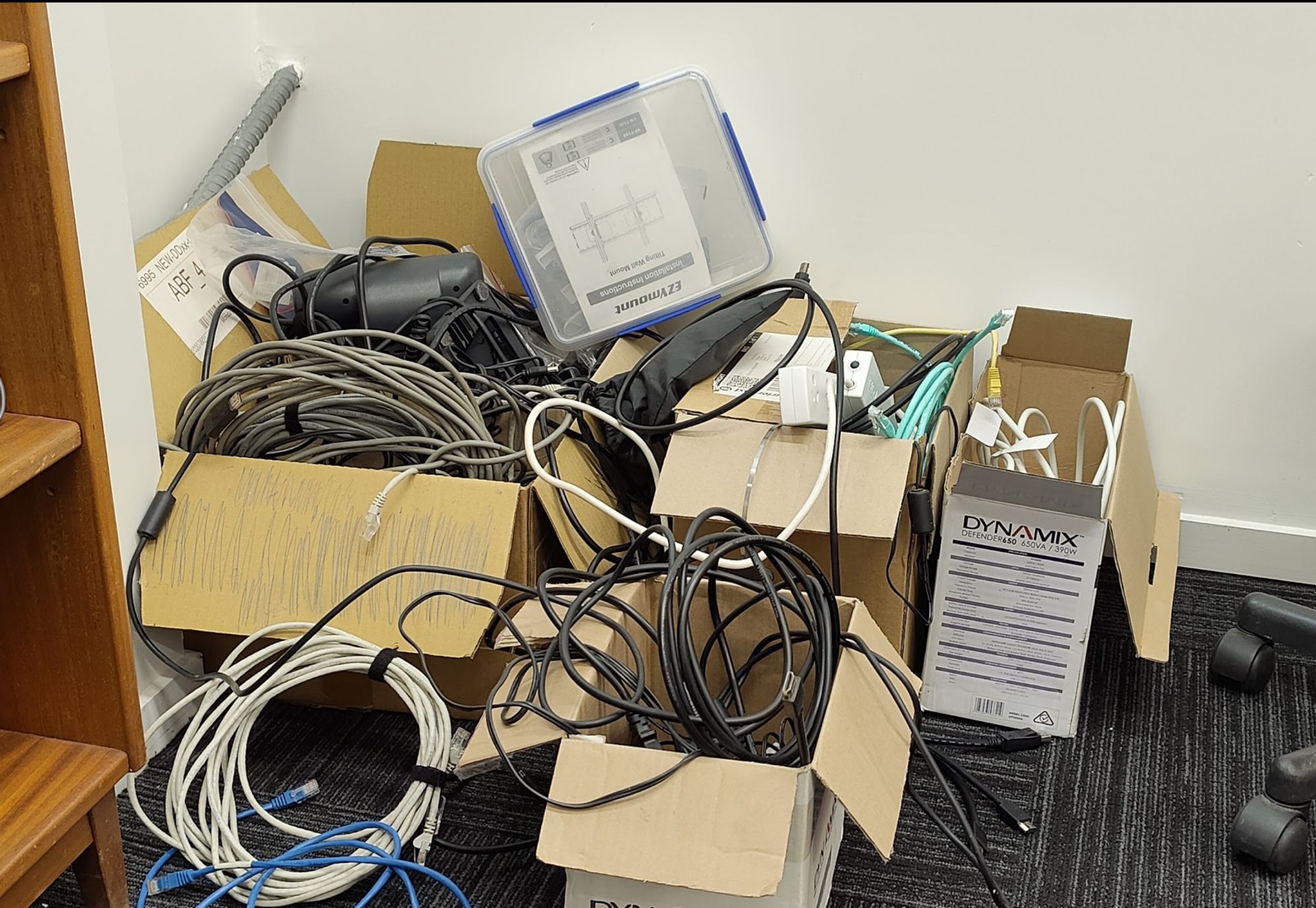 A mess of cables stored exceedingly well in cardboard boxes.