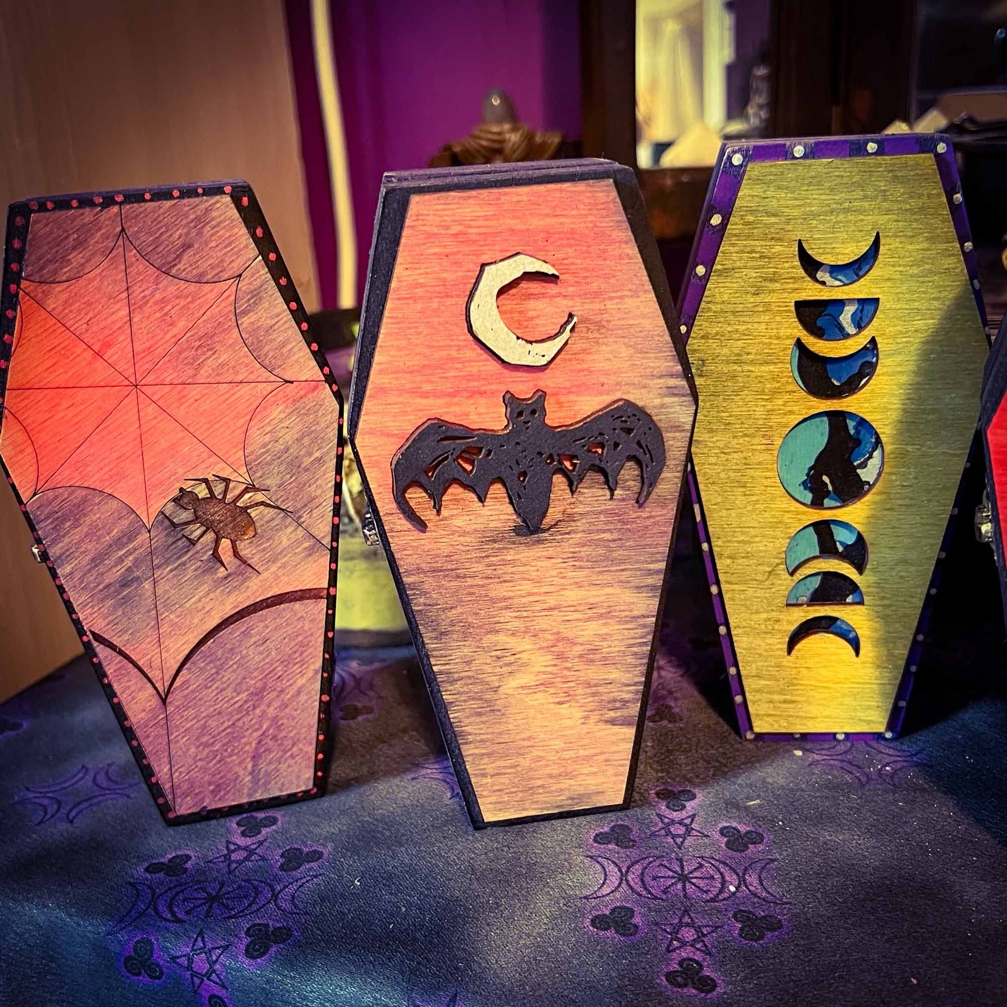 3 hand decorated coffin boxes with spider and web, bat and moon, and moon phase motifs