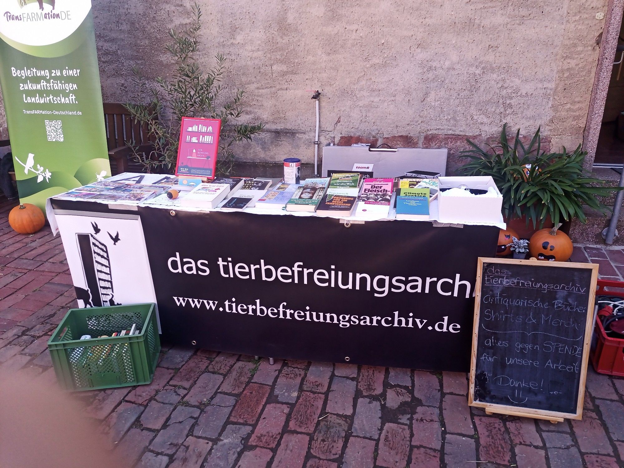 Ein Bücherstand mit einem Banner mit der Aufschrift "das tierbefreiungsarchiv"