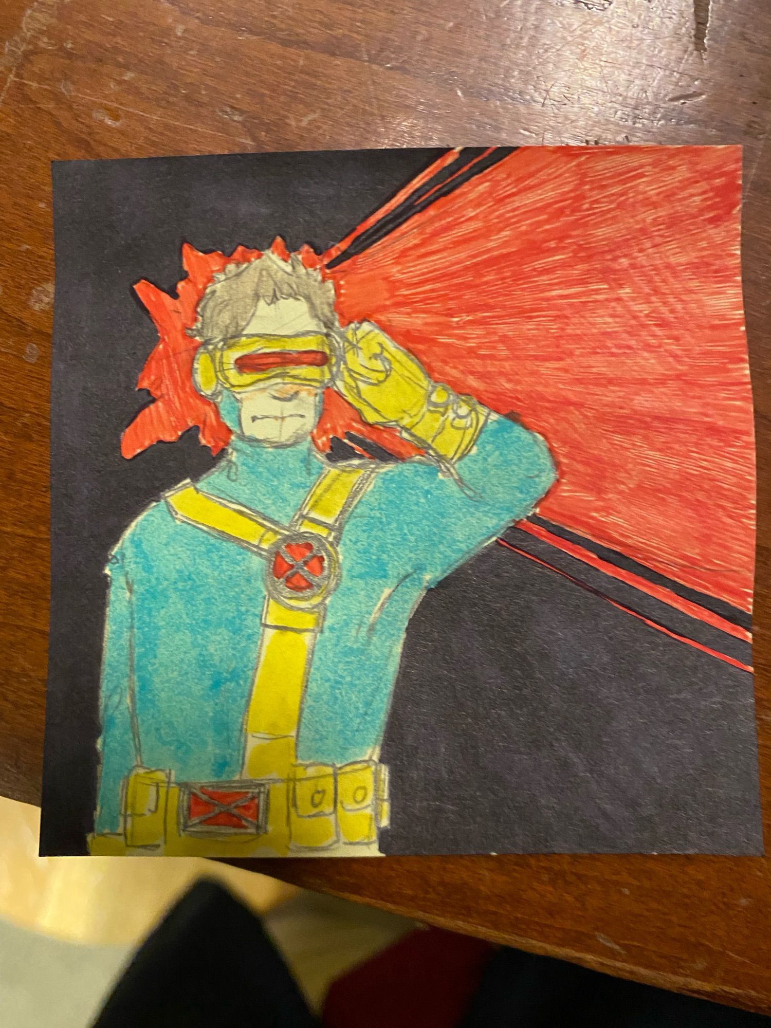 A pencil sketch on a sticky note of Cyclops from the X-Men in his 90’s uniform, colored with blue and yellow highlighter. He is looking to the right with his hand to his temple. Against a black background, the area surrounding his head and beaming out to the right is colored red.