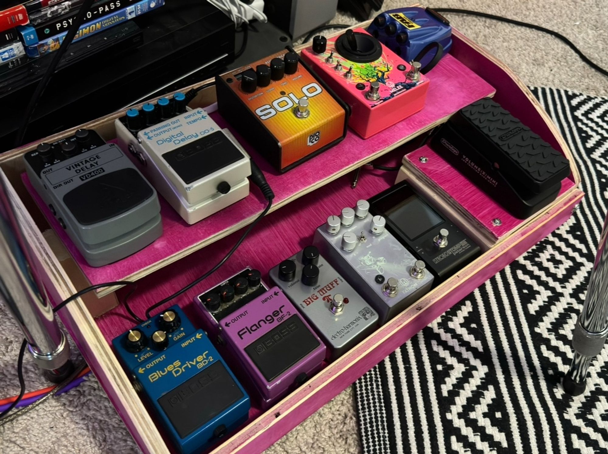 Two decker pedal board roughly 7 pedals wide completely stained pink