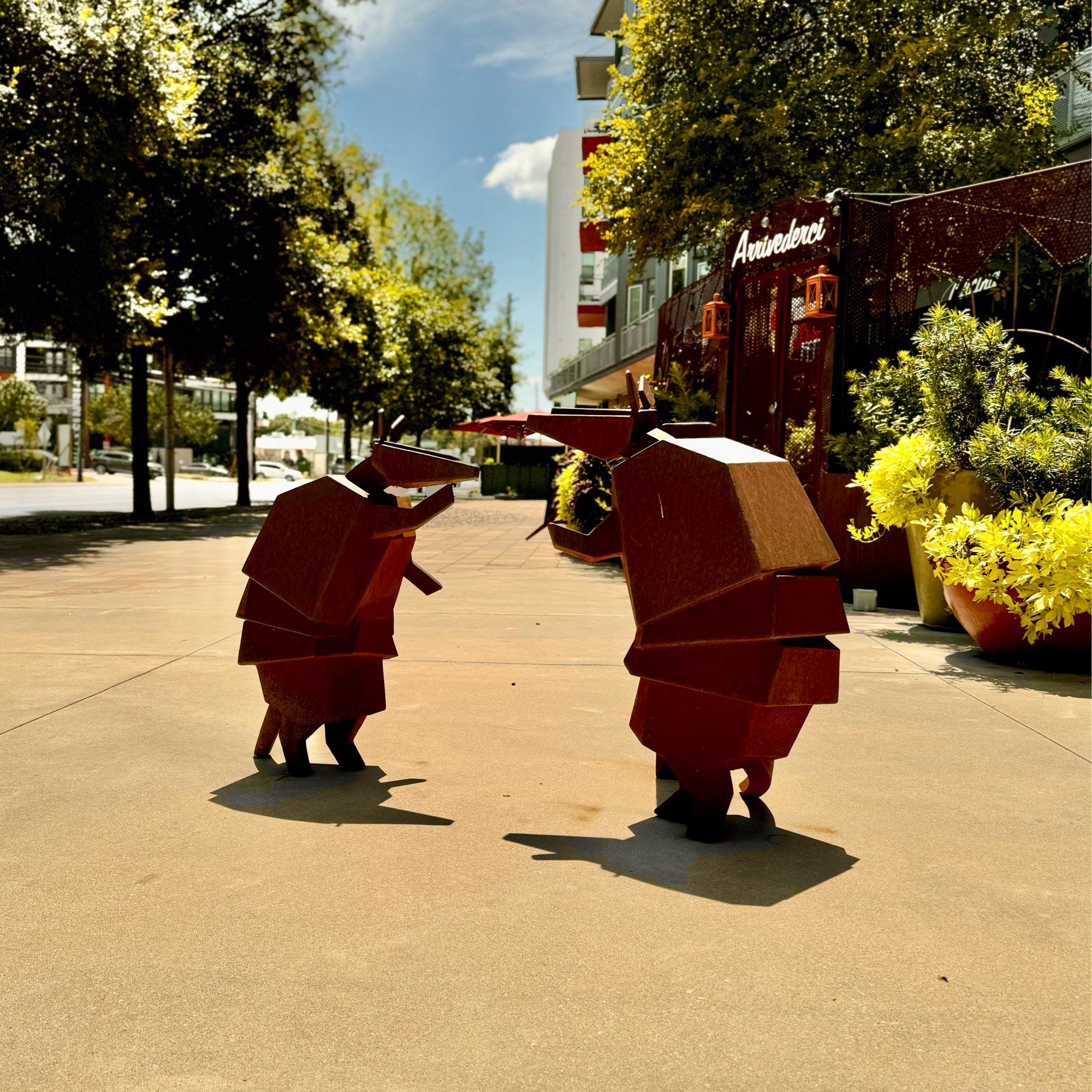 Two metal armadillos having a conversation standing upright on south Lamar in Austin