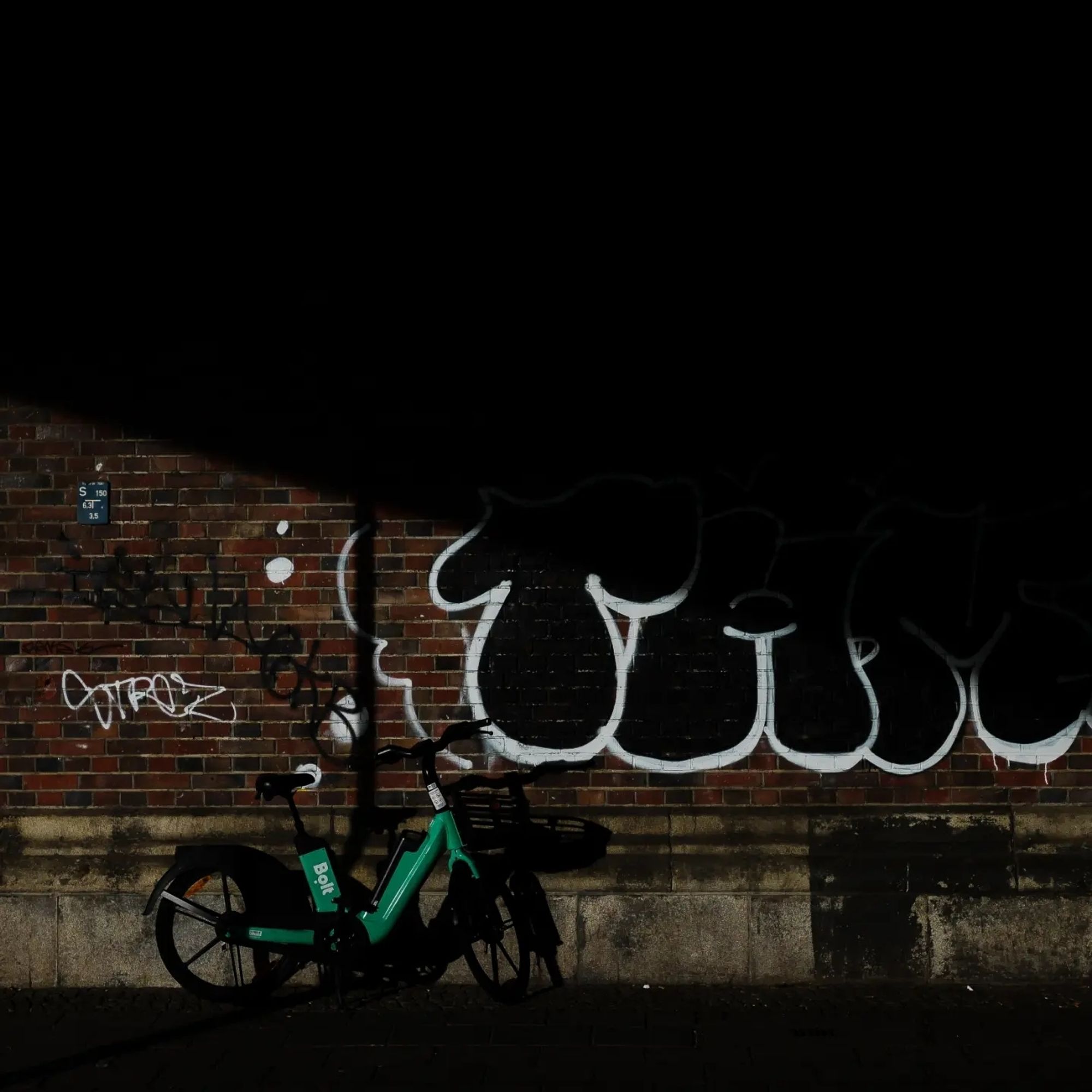 Berlin. Schatten und Licht, ein grünes Fahrrad und ein Graffito