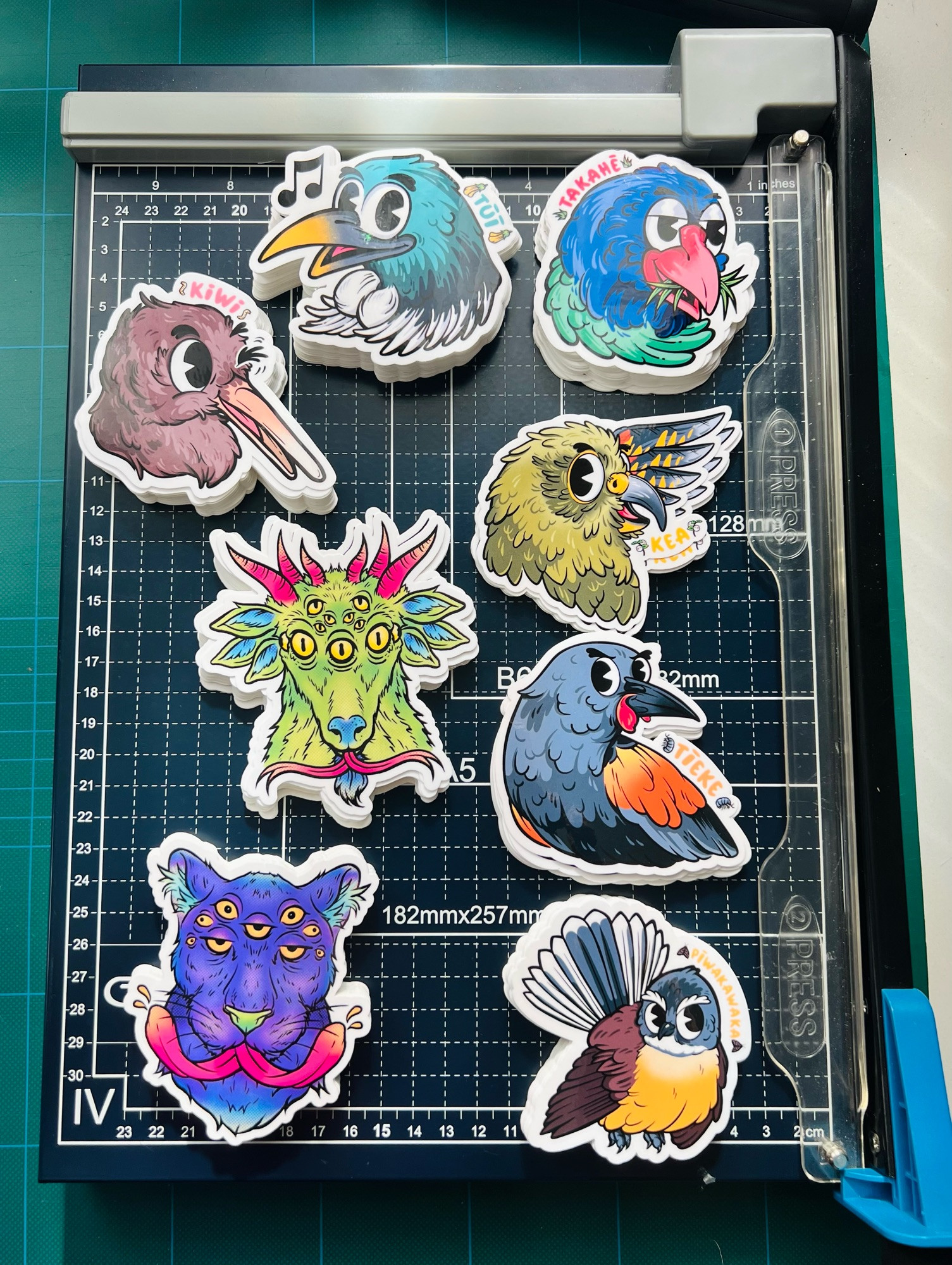 An array of brightly coloured Pepper Raccoon stickers on a cutting board 