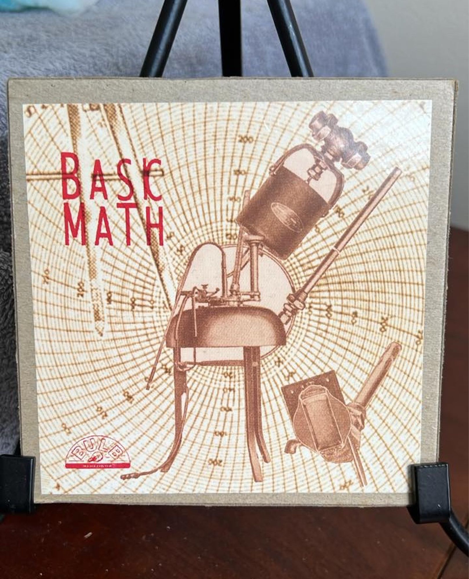 1994 Bulb Records compact disc reissue of Math's 'Bask Math', originally released on cassette by Milk Of Burgundy in 1993.