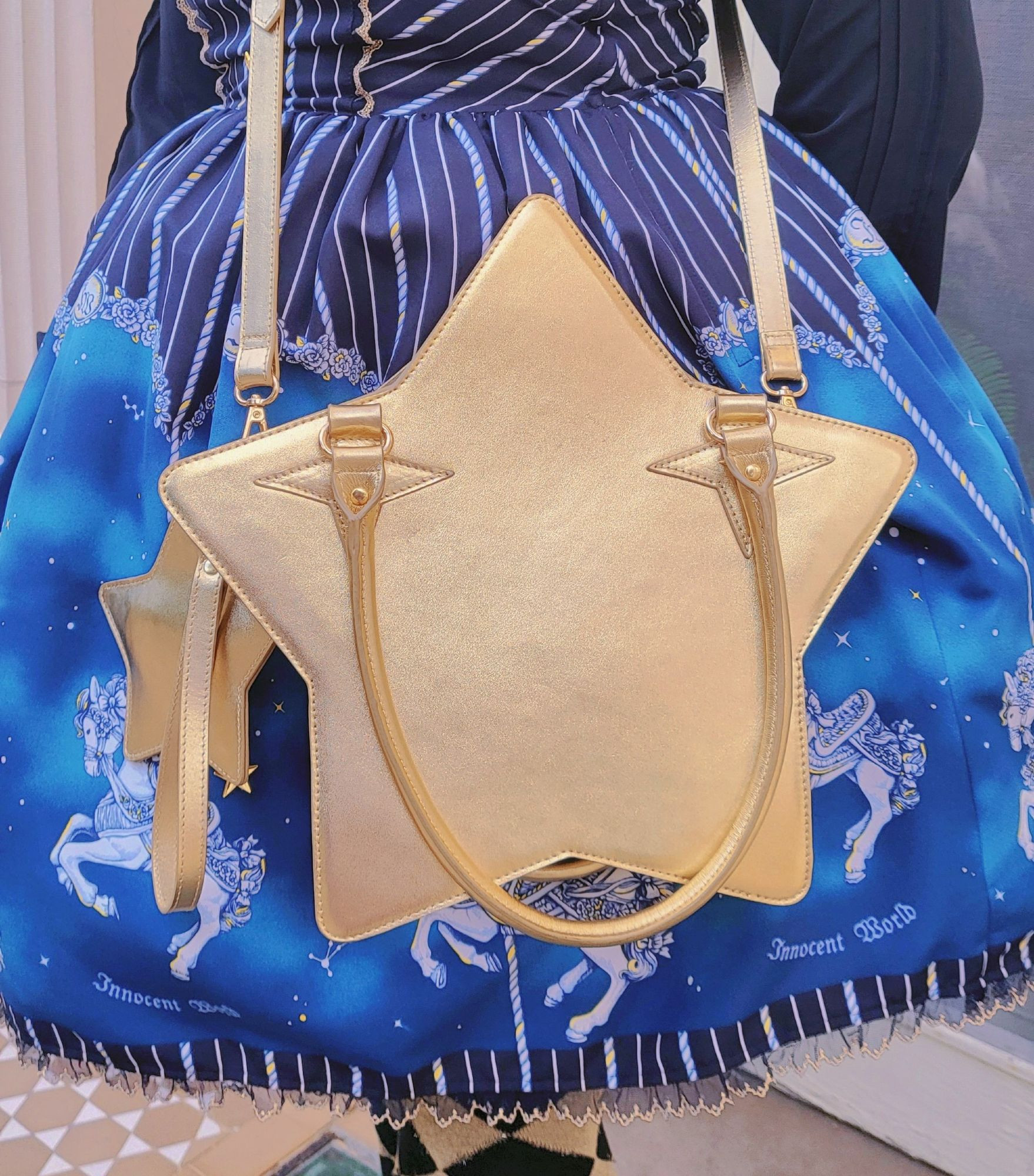 A gold star shaped bag & coin strap worn crossbody.