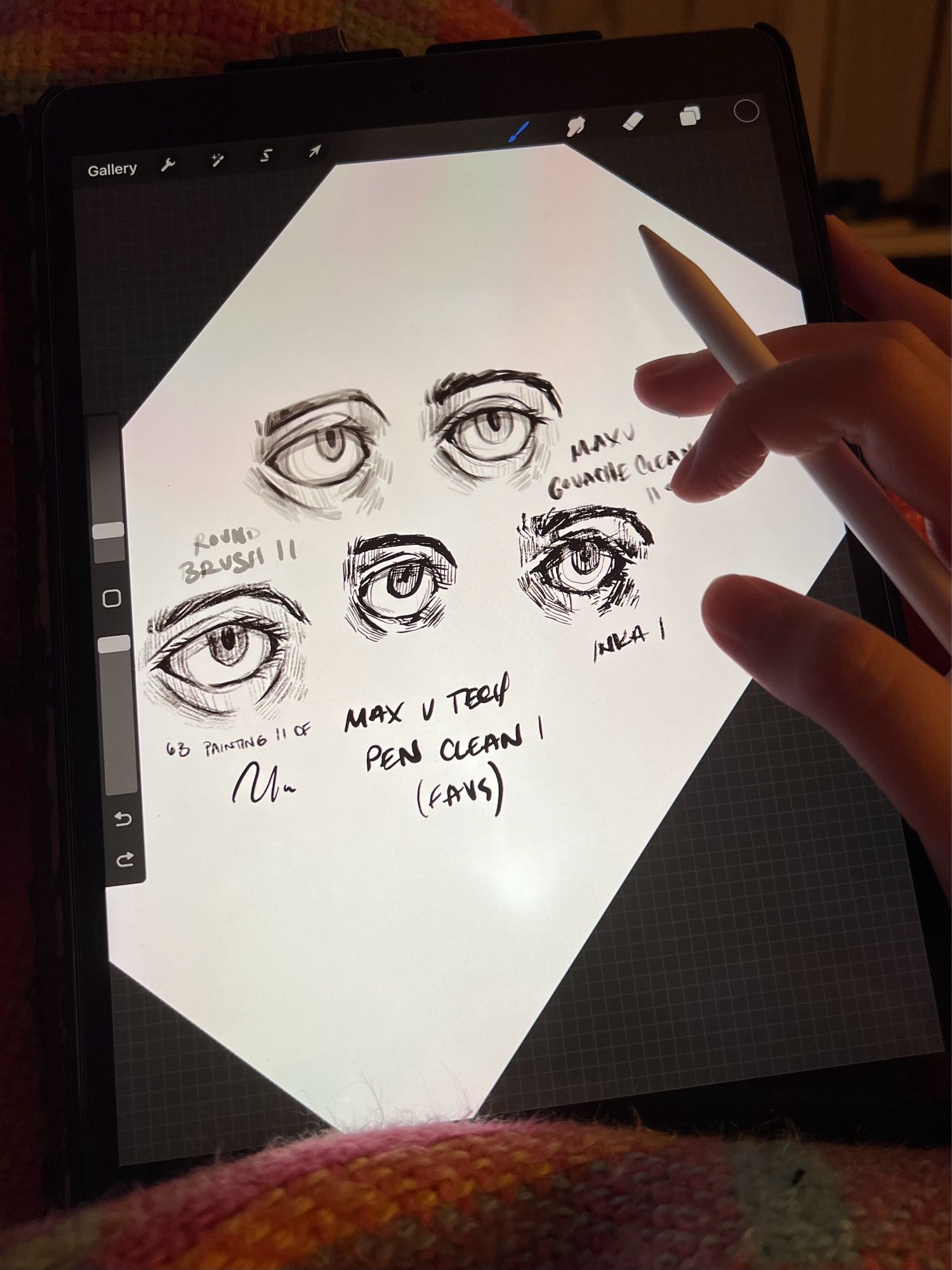 Picture of an iPad with the procreate drawing app open with 5 sketches of eyes of the canvas, each drawn with a different digital brush (noted near each eye)