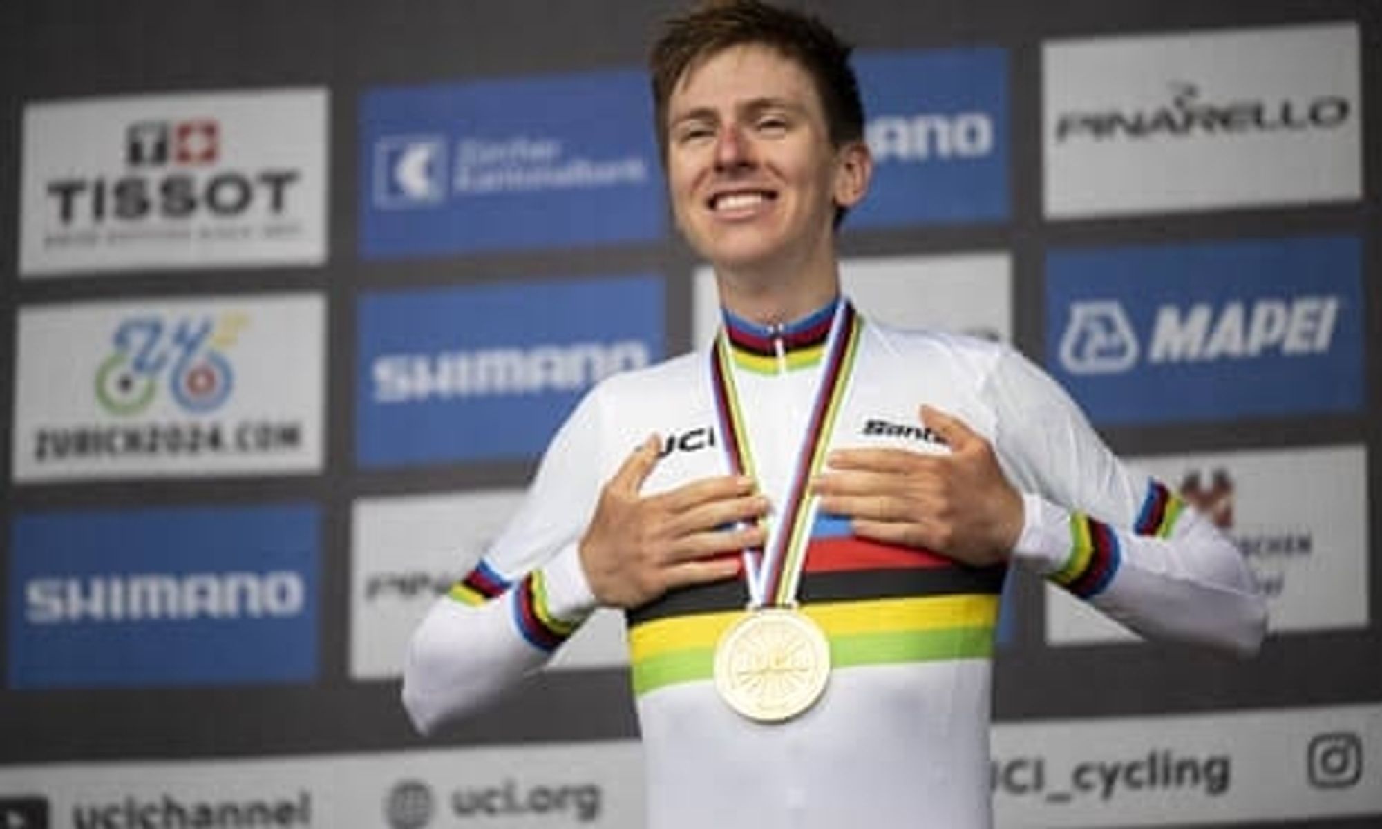 Tadej Pogacar campeão mundial de ciclismo, no pódio com medalha de ouro e rainbow jersey