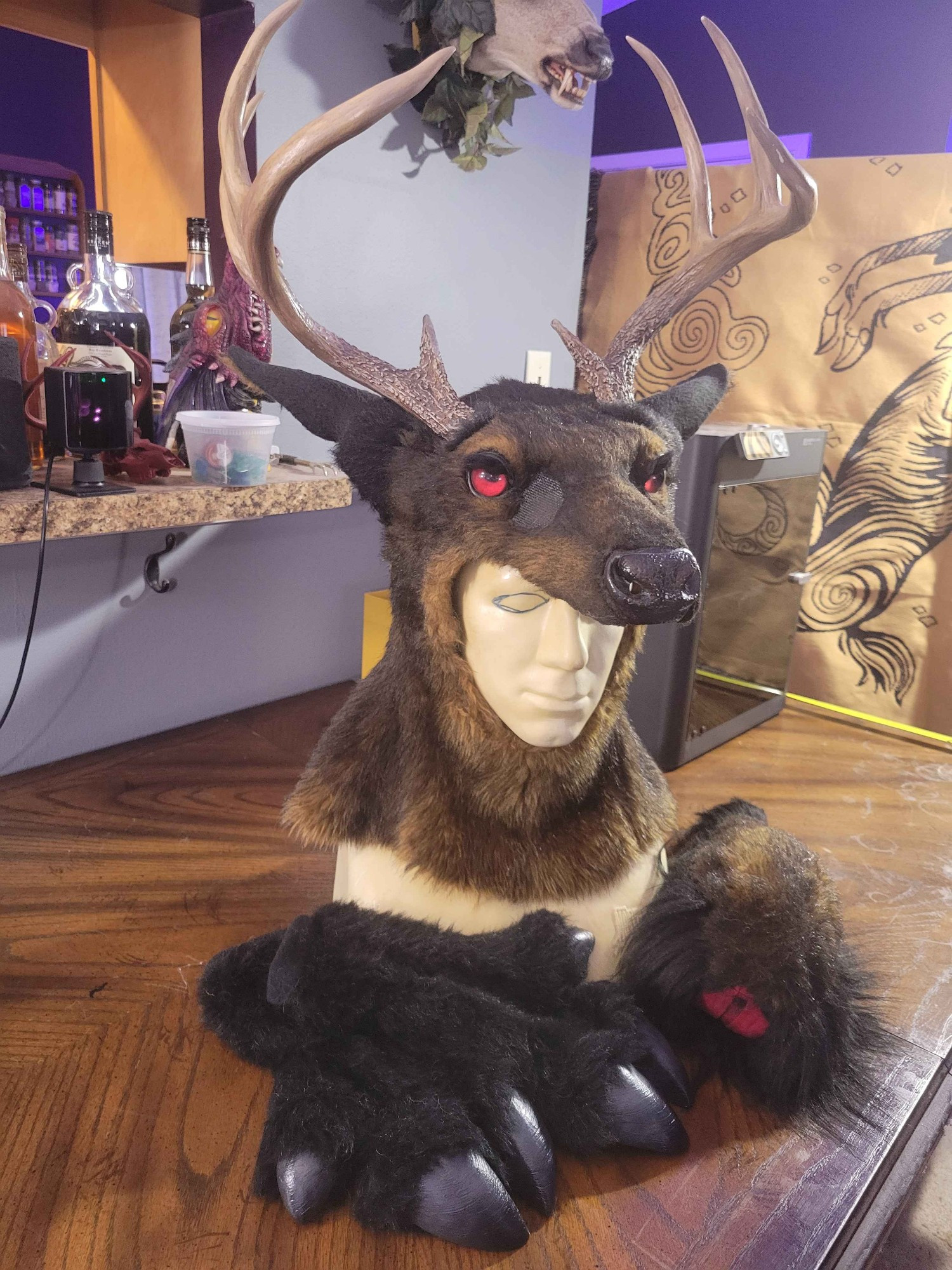 Dark brown stag half-mask with red eyes, black hoof gloves and a tail.