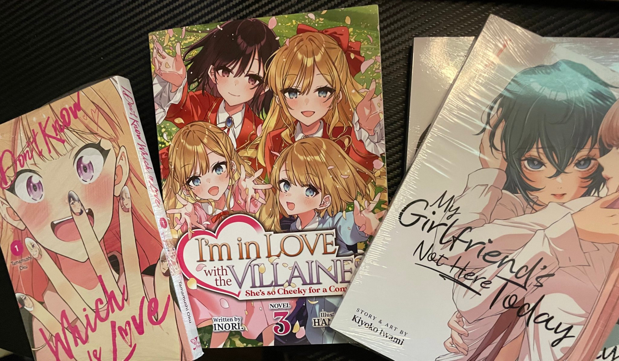 4 books on desk
in order from left to right:
I Don't Know Which is Love vol. 1
I'm In Love with the Villainess: She's So Cheeky for a Commoner Vol. 3
My Girlfriend's Not Here Today vol. 1 & 2