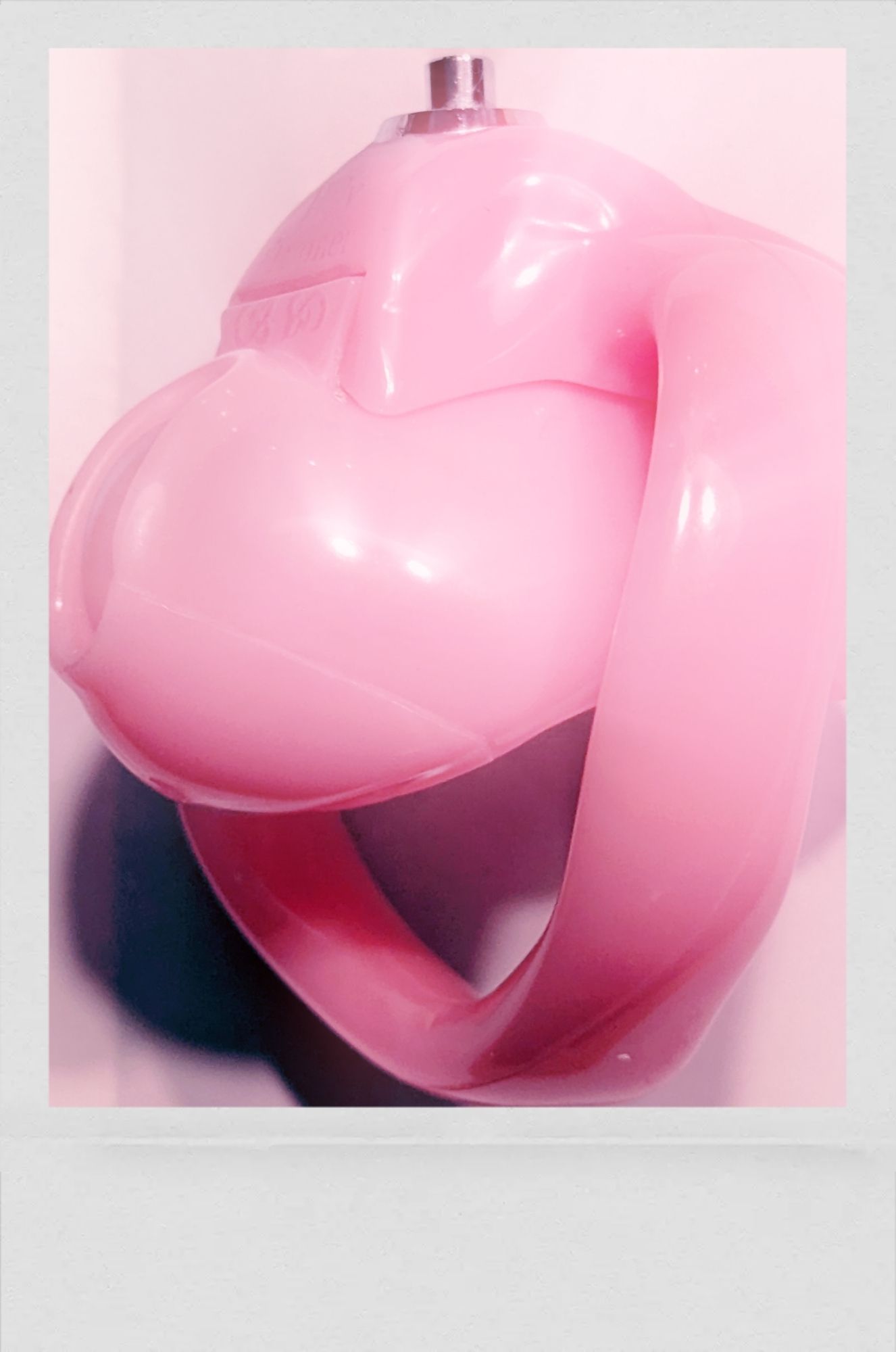 A very small pink chastity cage.