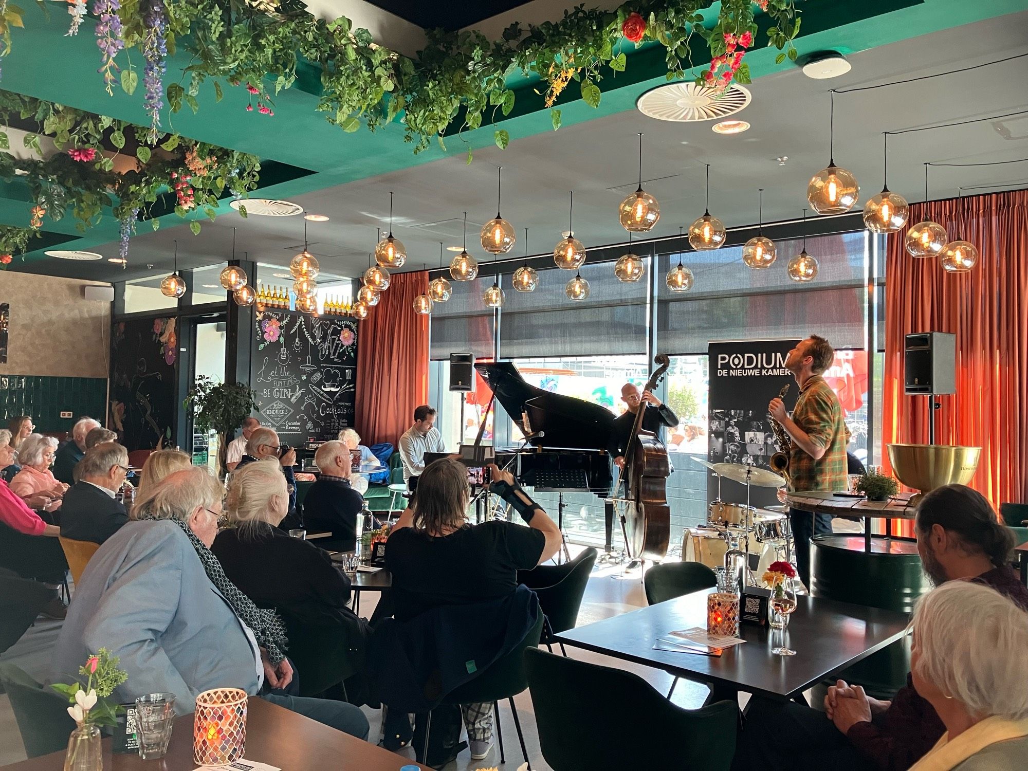 Kleurijk ingerichte Brasserie Almare met een paar musici op het podium