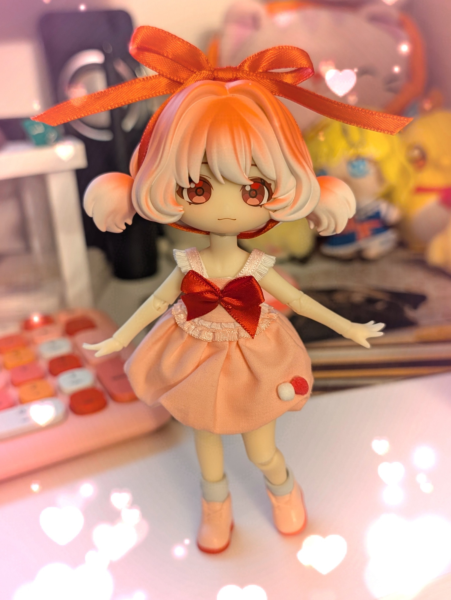 Ball Joint Doll, Berries, she has a red ribbon tied in her pink and white pigtailed hair, the bow rests on the top of her head 