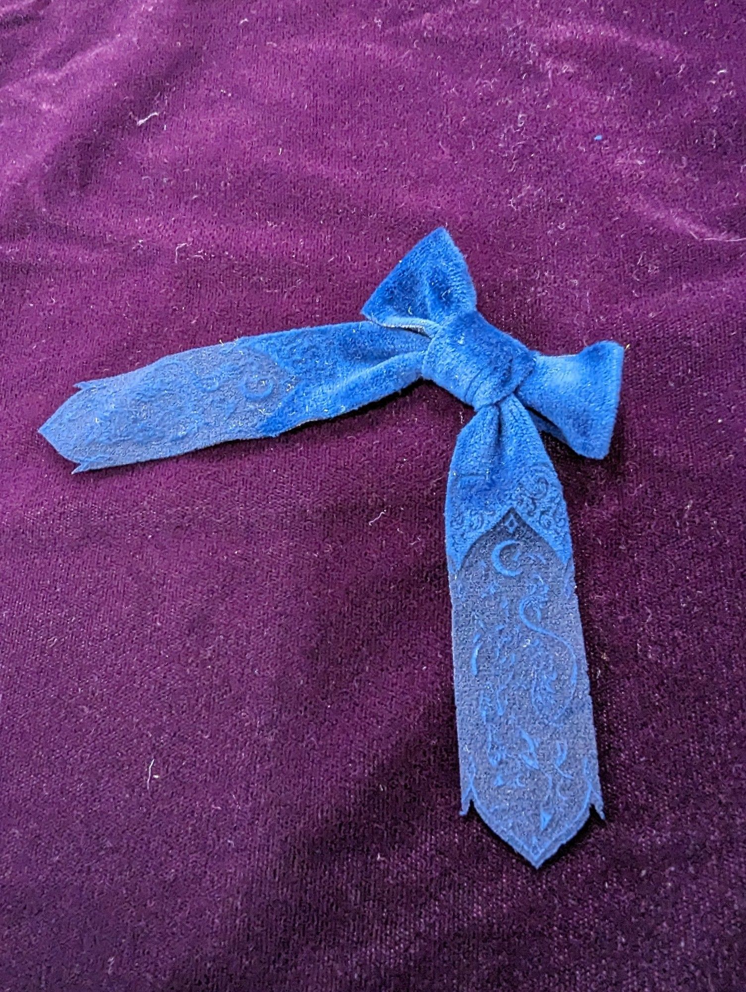 Miniature prototype of blue velvet ribbon with unicorn design on tail