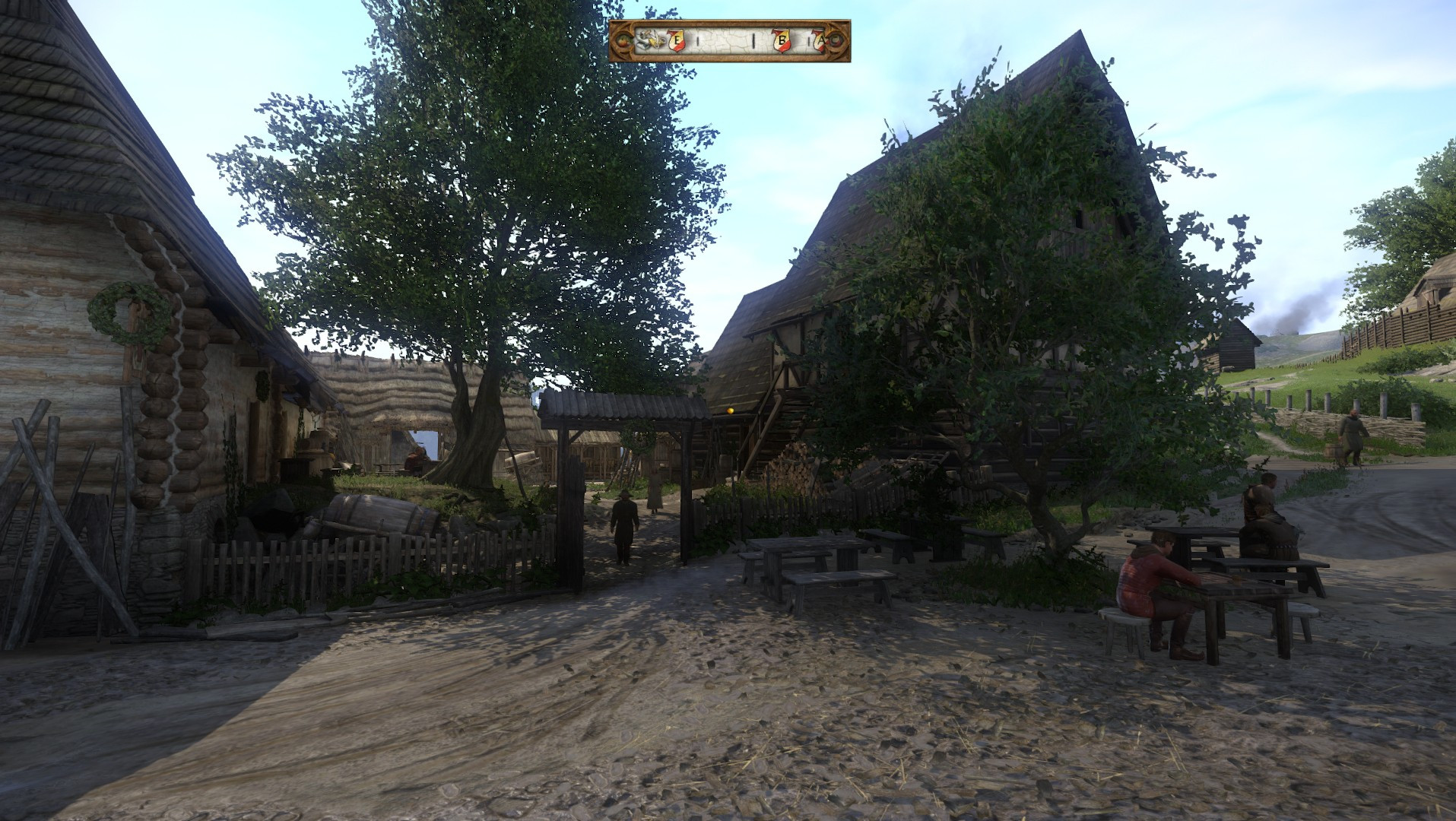 A Scene from the game Kingdom Come Deliverance.
It is the Inn of Skalitz in the year 1403.
It is a sunny summer day.
To the left is the Inn, whitewashed walls made of Logs, its perspective angle goes sharp to the back of the scene. To its right, in front of it is a gnarled, old tree in its prime. Around it are tables where people sit and talk. In front of the Inn and Tree is a flimsy fence and a gate.
Opposite the Inn is an even bigger building with which it shares this fenced in yard. 
Outside the yard in the forefront of the picture is a smaller but even so lush tree. It is also surrounded by tables and benches. One villager is waiting for someone to play dice with.
The mud surrounding him is heavily tread on.