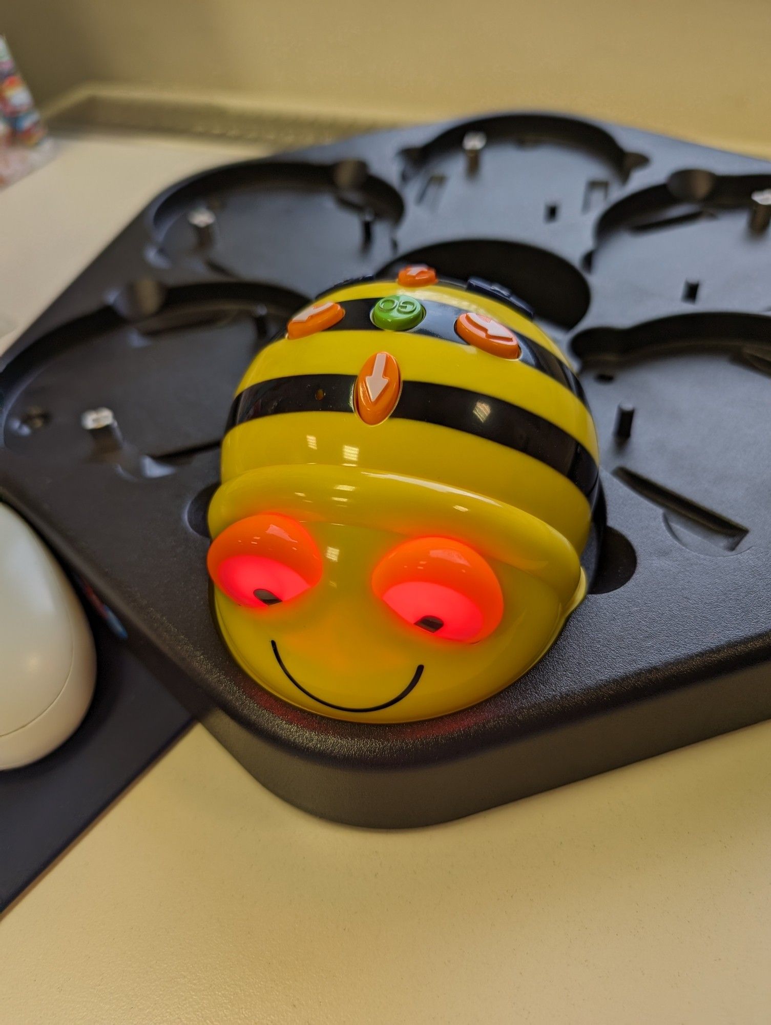 Lernroboter Beebot mit leuchtenen roten Augen, wird gerade aufgeladen