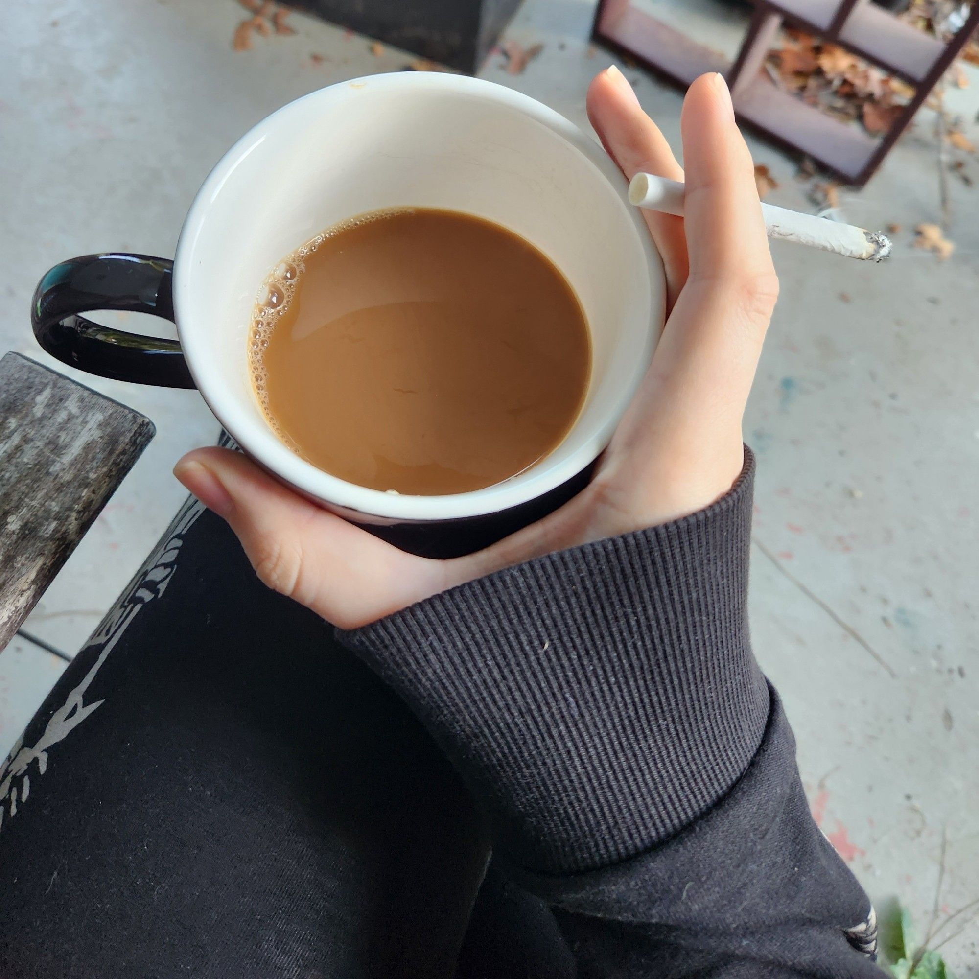 null is sitting outside with a cup of coffee and a cig. this not a breakfast and you shouldnt smoke.