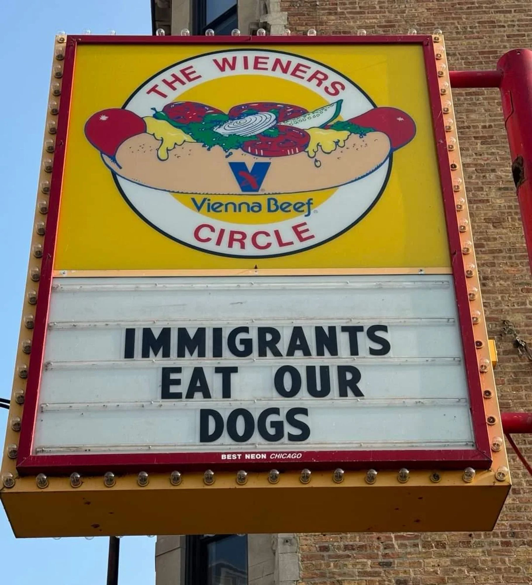 The sign of the hot dog shop The Wieners Circle, reading IMMIGRANTS EAT OUR DOGS.